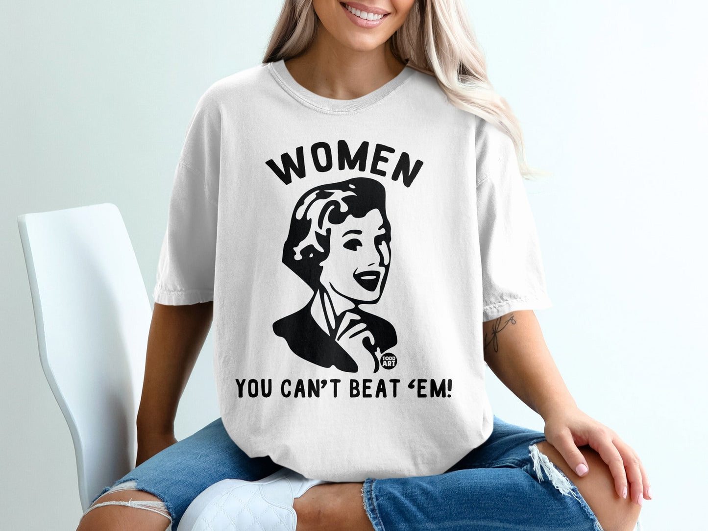 T-shirt with "WOMEN YOU CAN'T BEAT 'EM!" slogan and vintage woman illustration.
