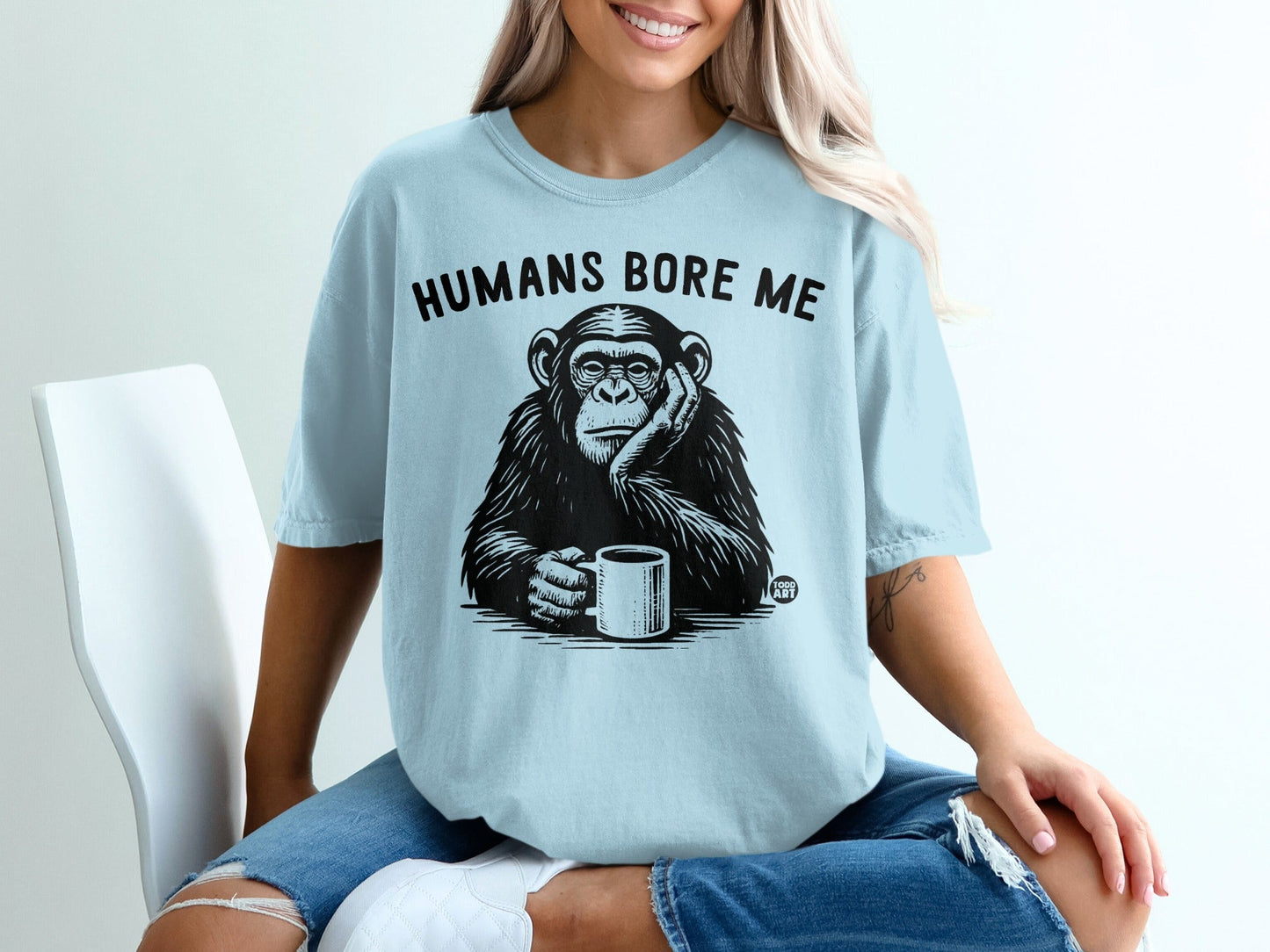 Light blue t-shirt with a chimpanzee holding a coffee cup, text "HUMANS BORE ME".