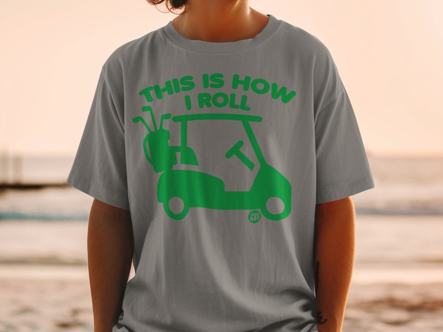 Grey t-shirt with green graphic of a golf cart and text "THIS IS HOW I ROLL".