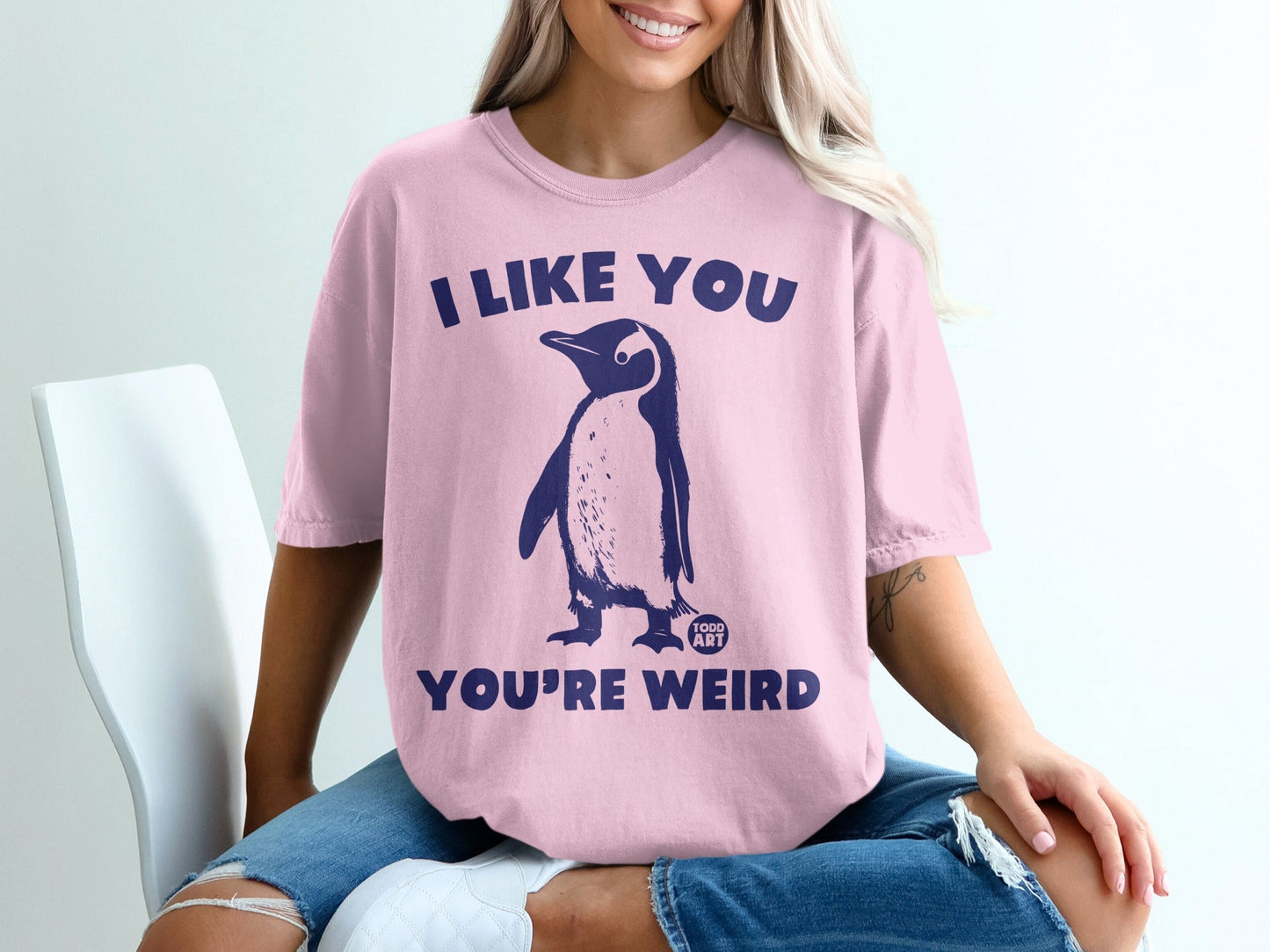 Pink t-shirt with navy penguin graphic and text "I LIKE YOU YOU'RE WEIRD".