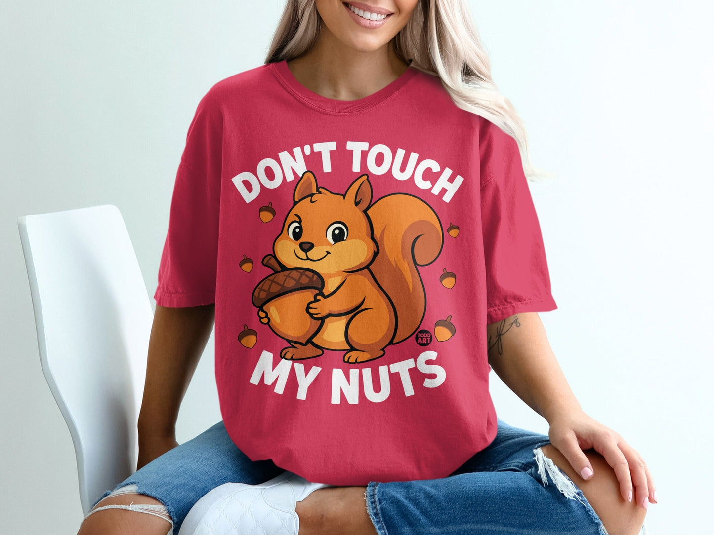 Red t-shirt with a cartoon squirrel holding an acorn and text "Don't Touch My Nuts."
