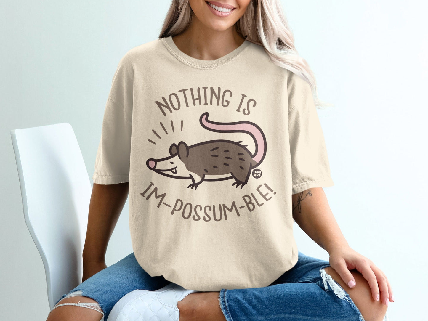 T-shirt with a graphic of a possum and the text "Nothing is Im-possum-ble!"
