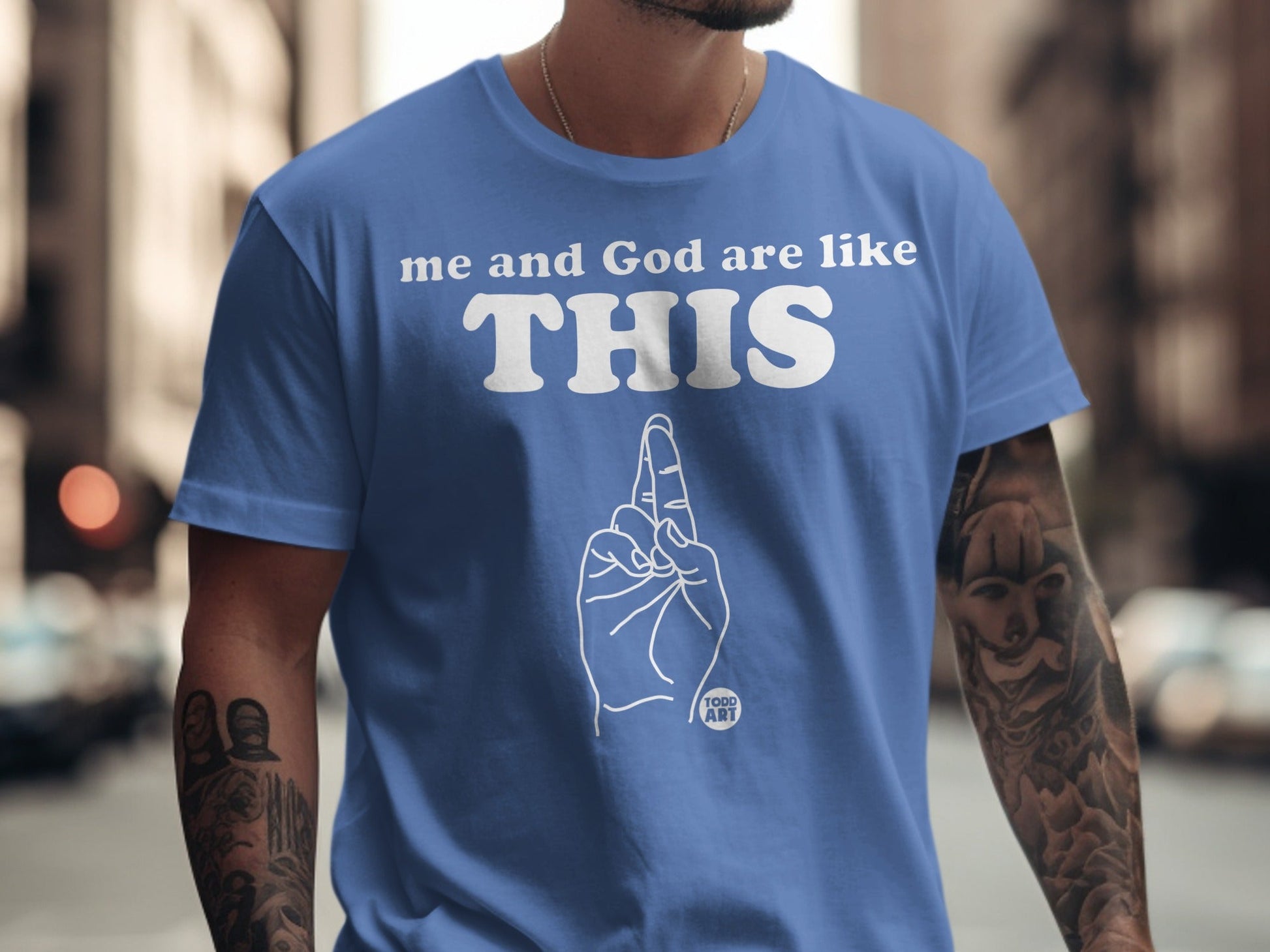 Blue t-shirt with "me and God are like THIS" and a hand gesture.