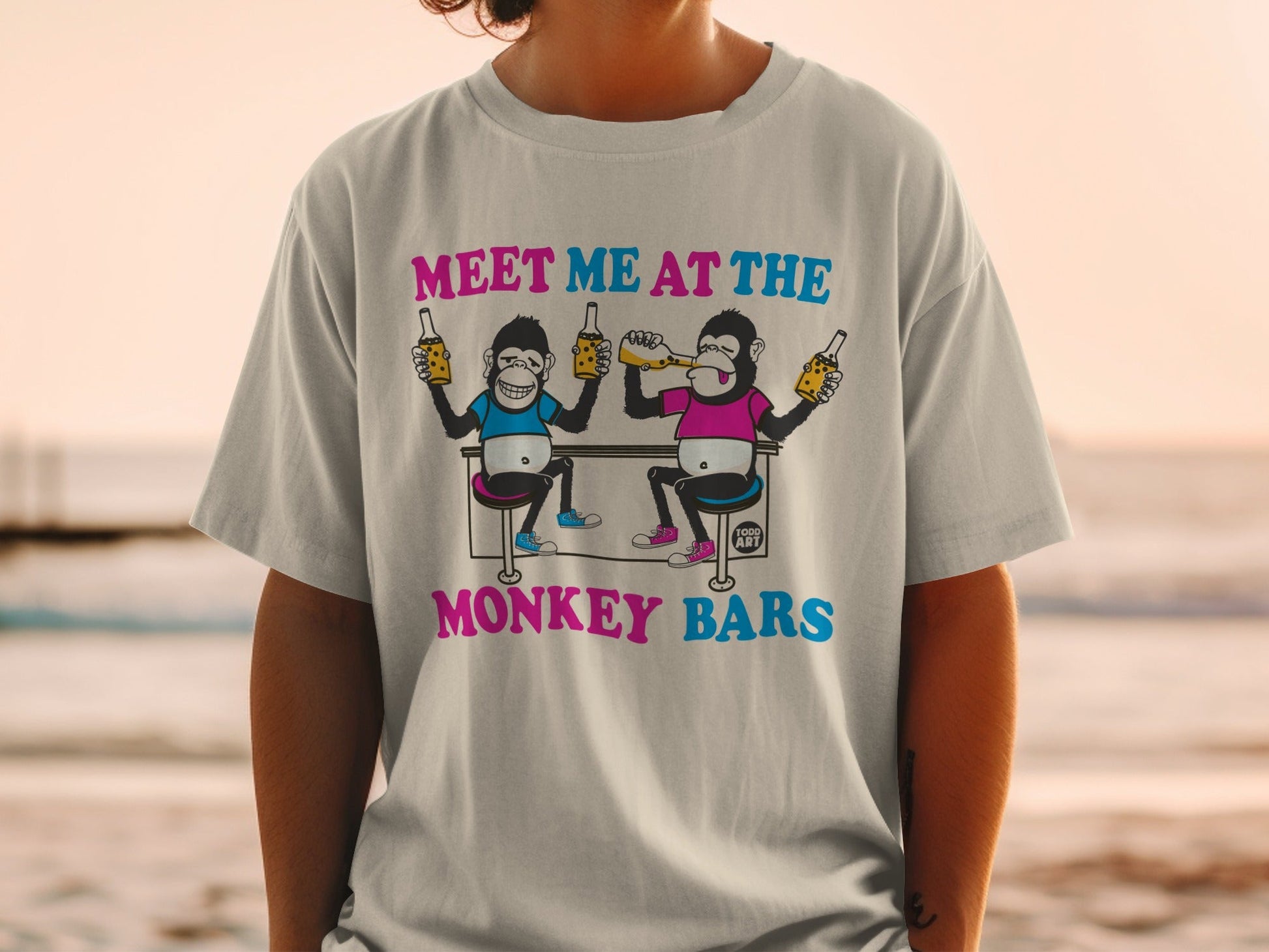 T-shirt with cartoon monkeys drinking beer at a bar, text "MEET ME AT THE MONKEY BARS".