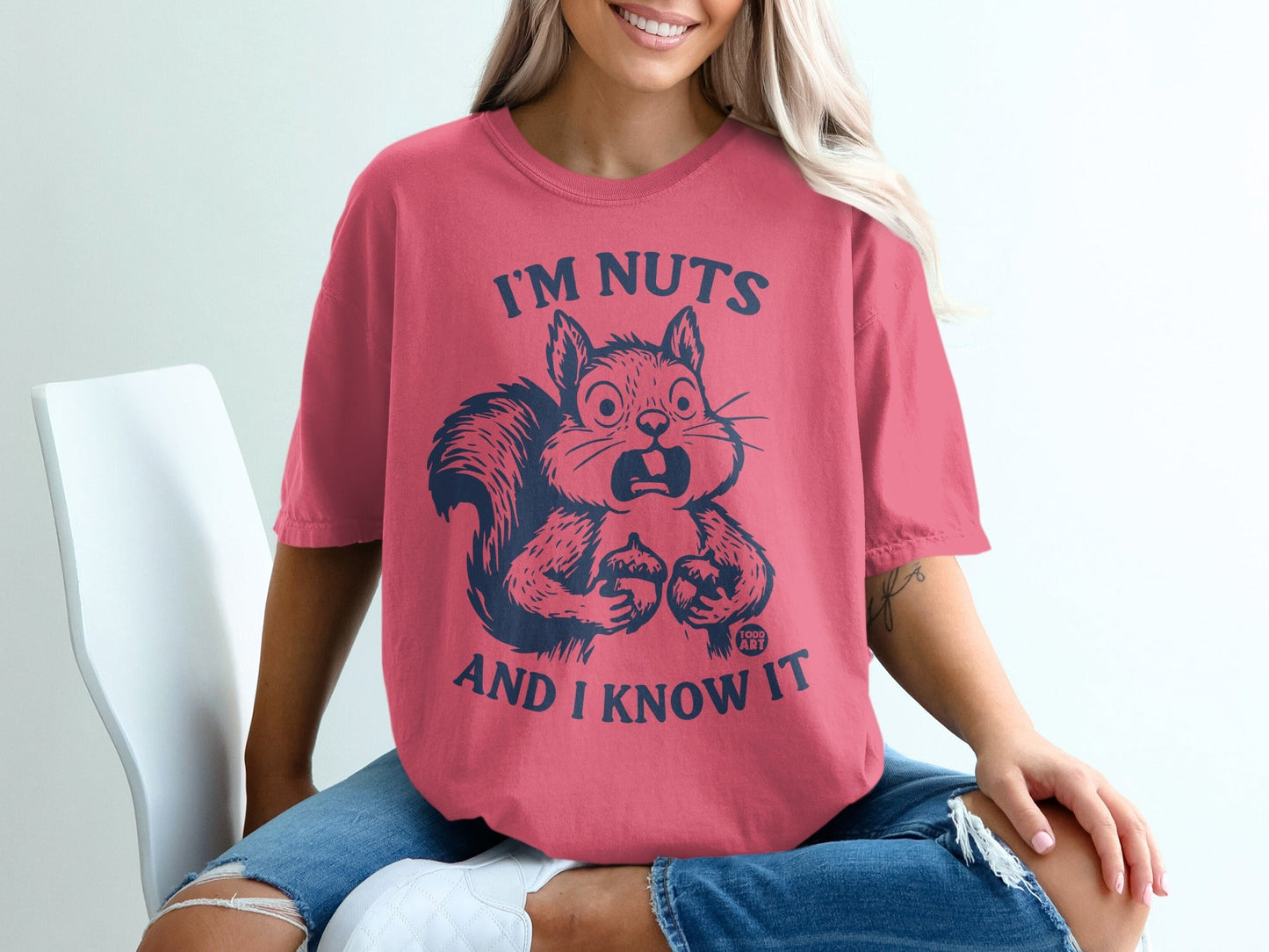 Pink t-shirt with graphic of a surprised squirrel and text "I'M NUTS AND I KNOW IT".