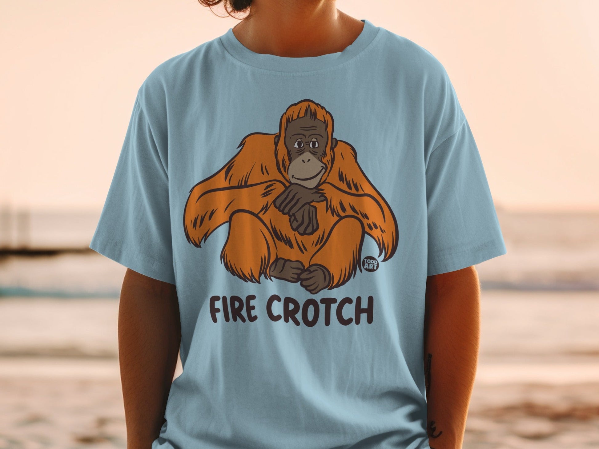 Light blue t-shirt with an orangutan and "FIRE CROtch" text.
