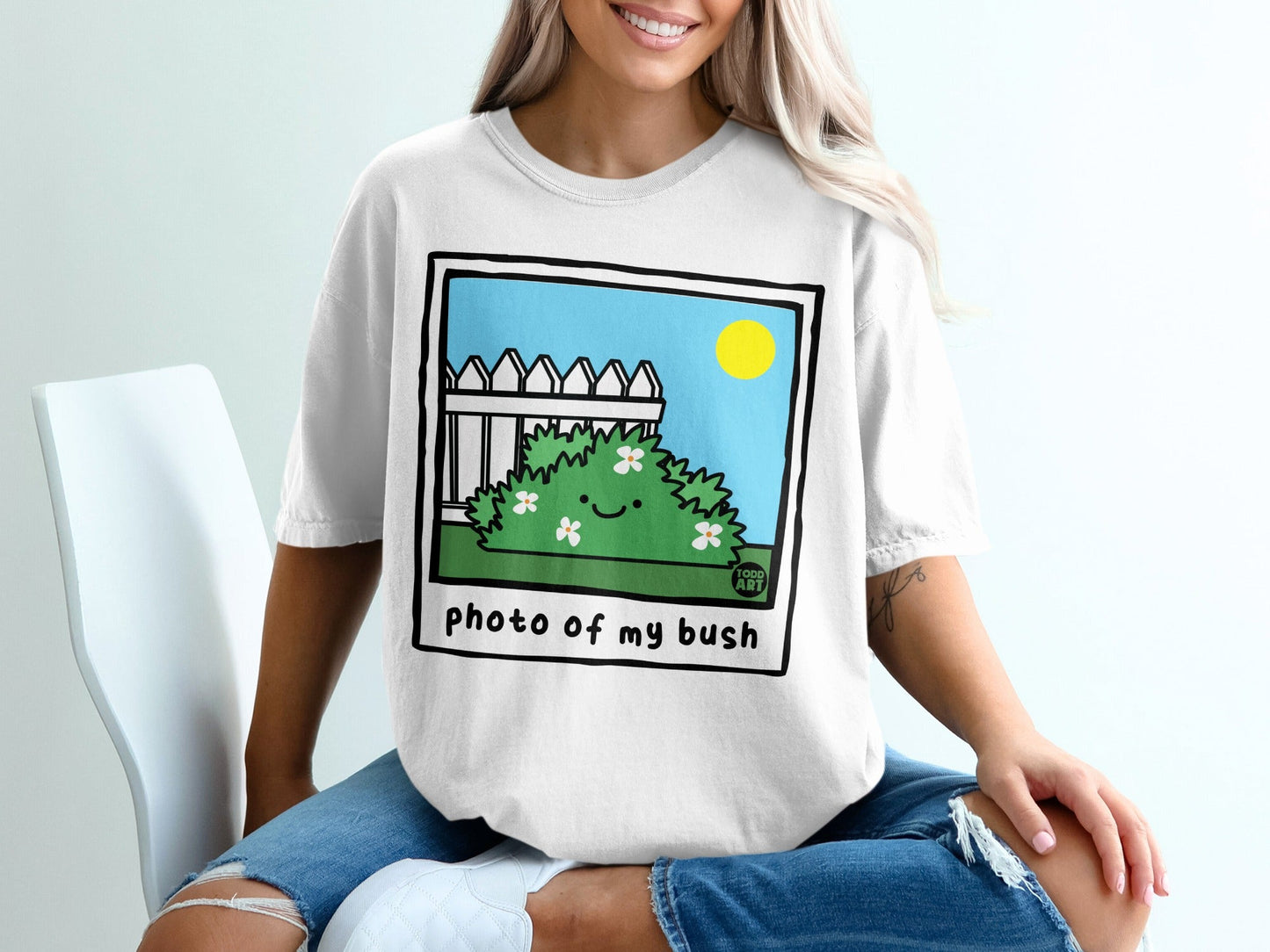 Cartoon bush with happy face on white t-shirt with "photo of my bush" text.