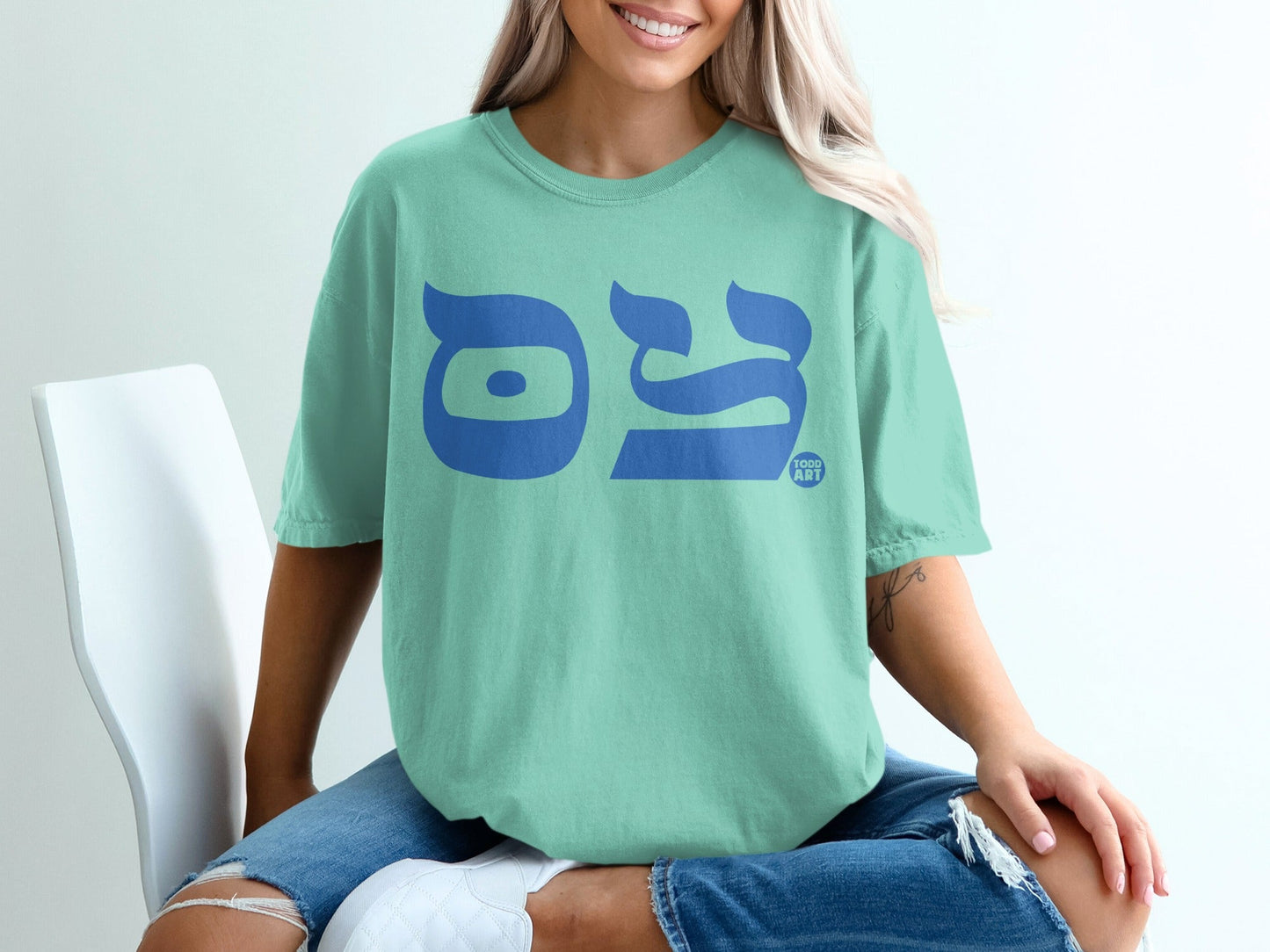 Teal t-shirt with blue Hebrew letters for "TODD ART" across the chest.