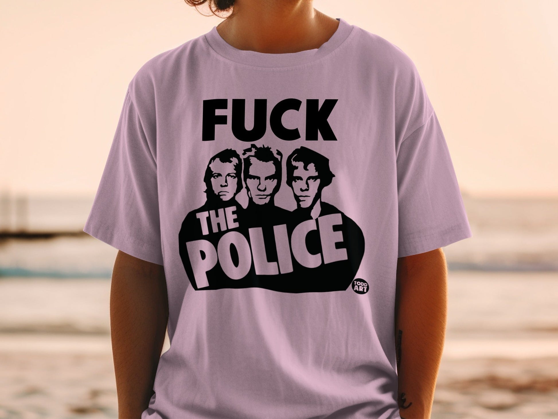 Light purple t-shirt with black text and an image of three men.