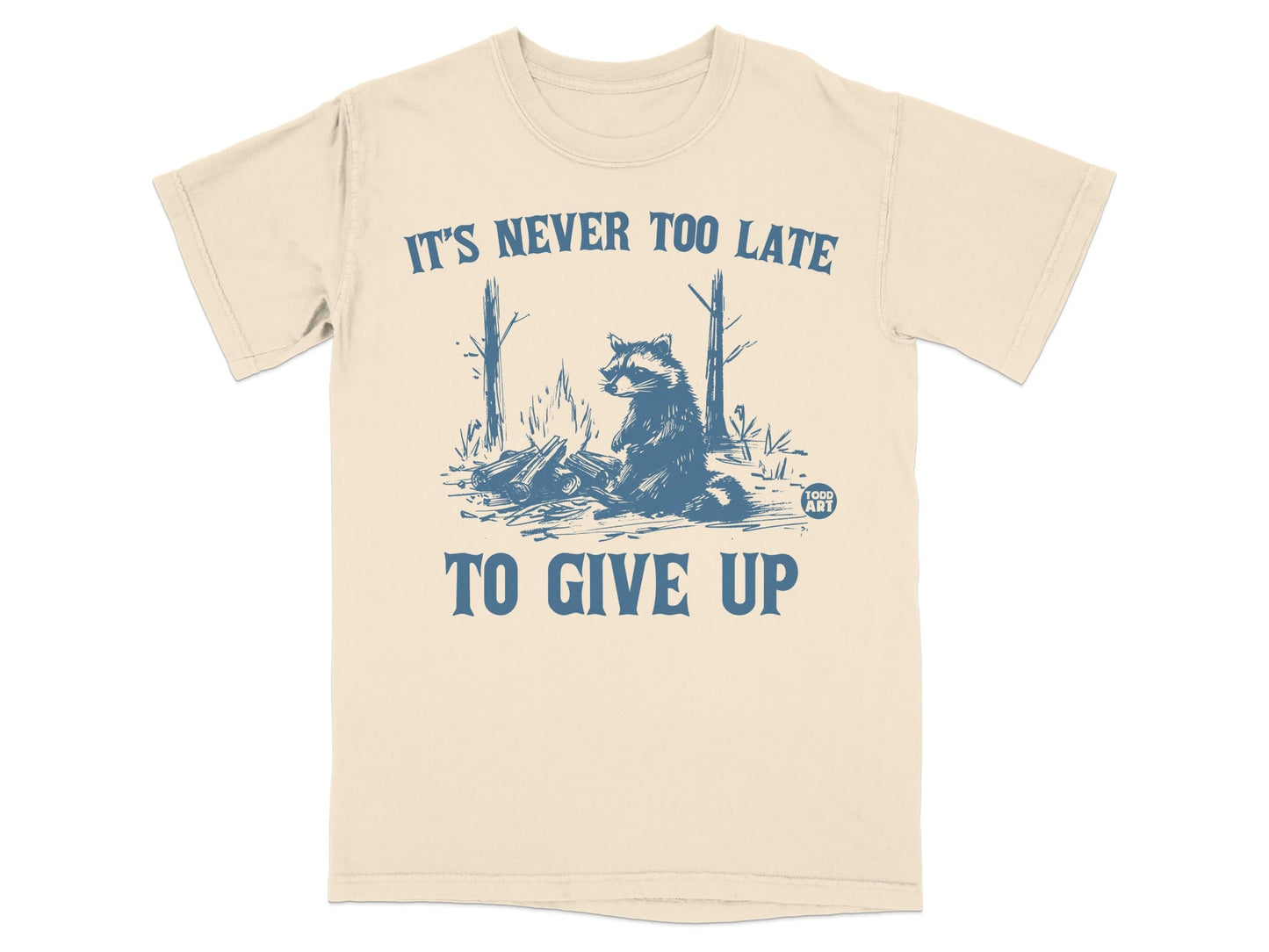 T-shirt with raccoon by campfire and text "It's never too late to give up."