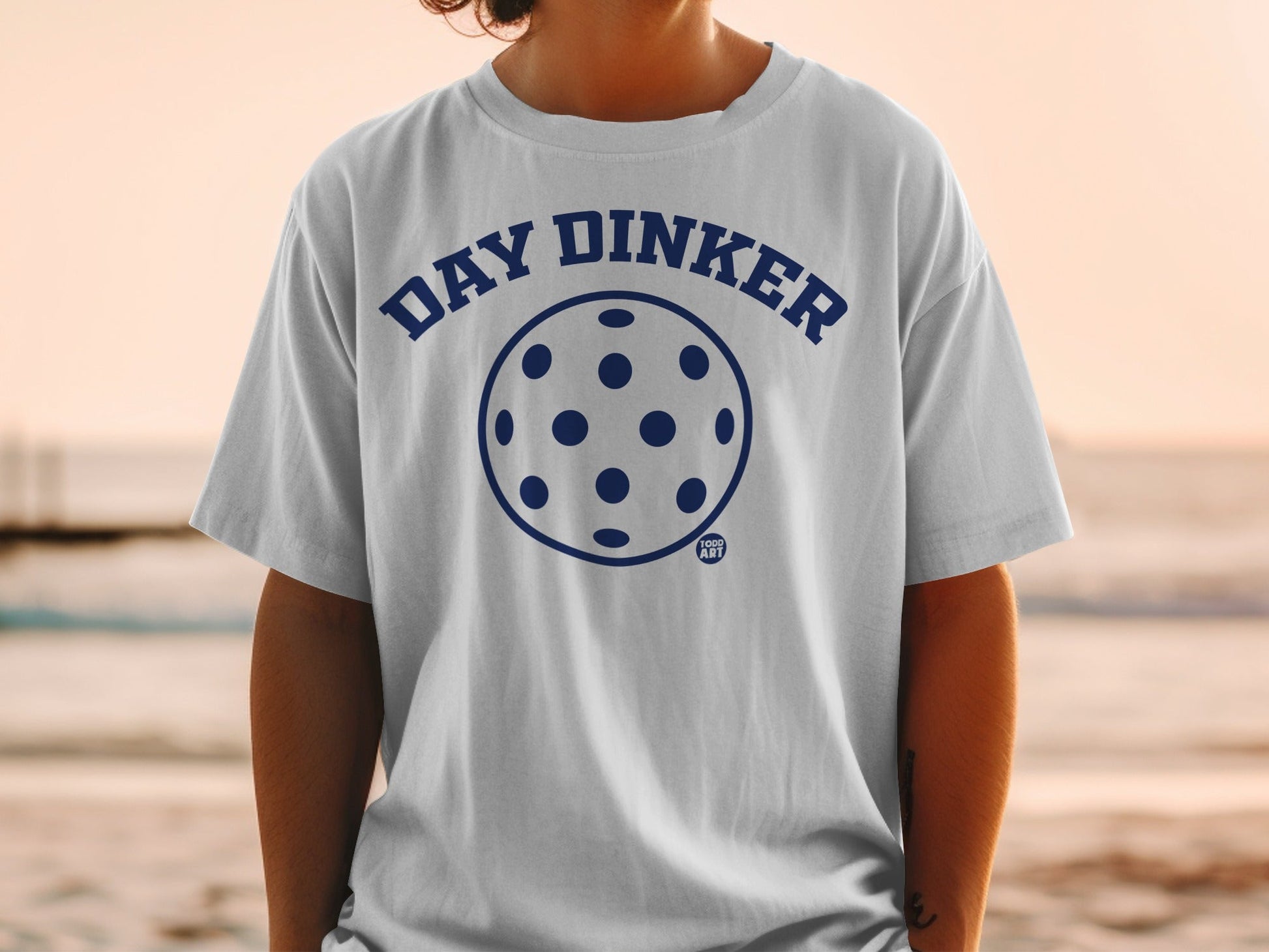 White t-shirt with navy blue "DAY DINKER" pickleball graphic.