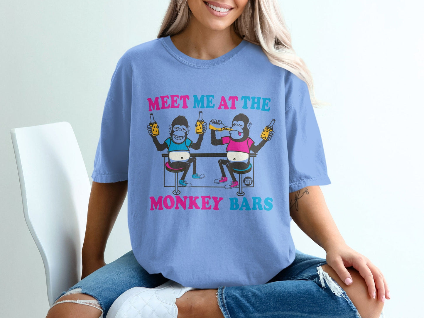 T-shirt with cartoon monkeys at a bar, text reads "MEET ME AT THE MONKEY BARS".