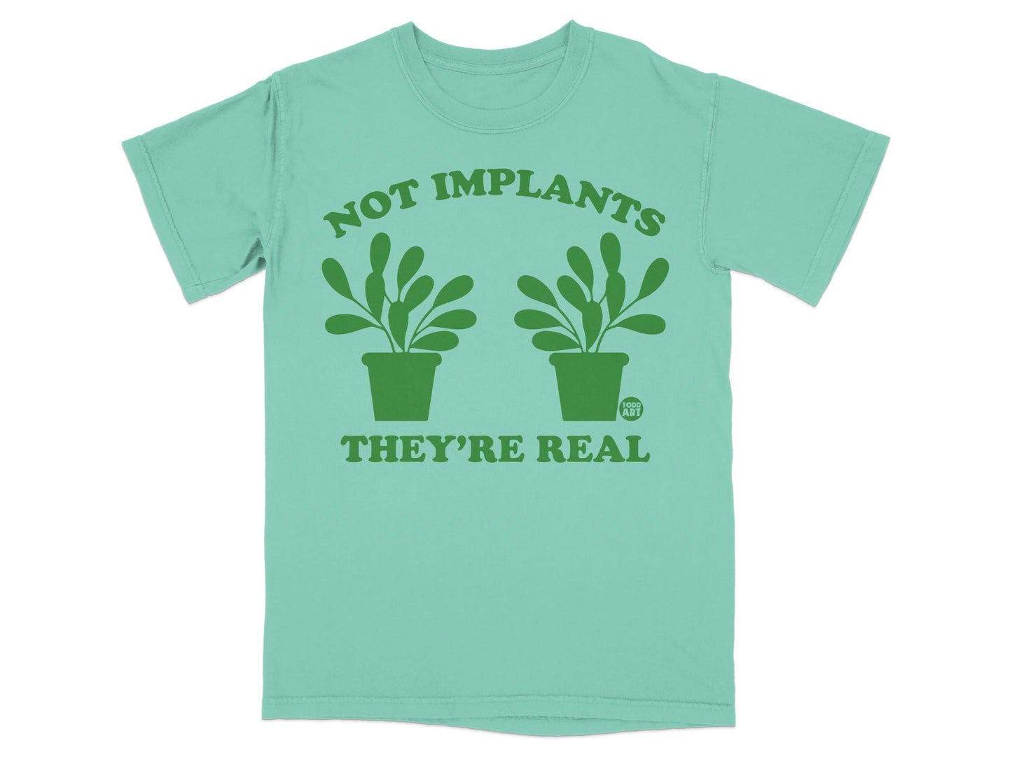 Mint t-shirt with green text "NOT IMPLANTS THEY'RE REAL" and two potted plants.