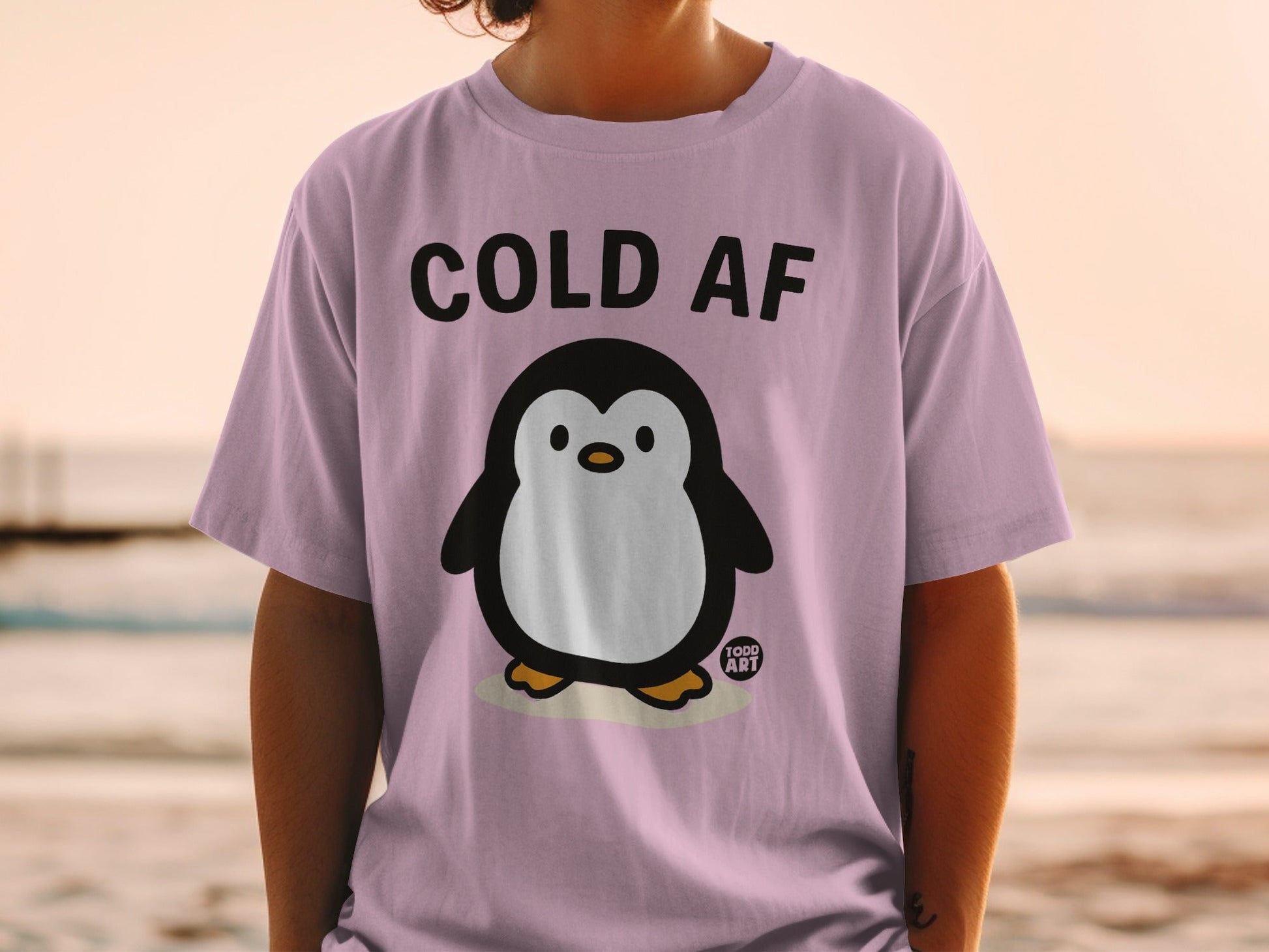 Purple t-shirt with a cartoon penguin and "COLD AF" text.