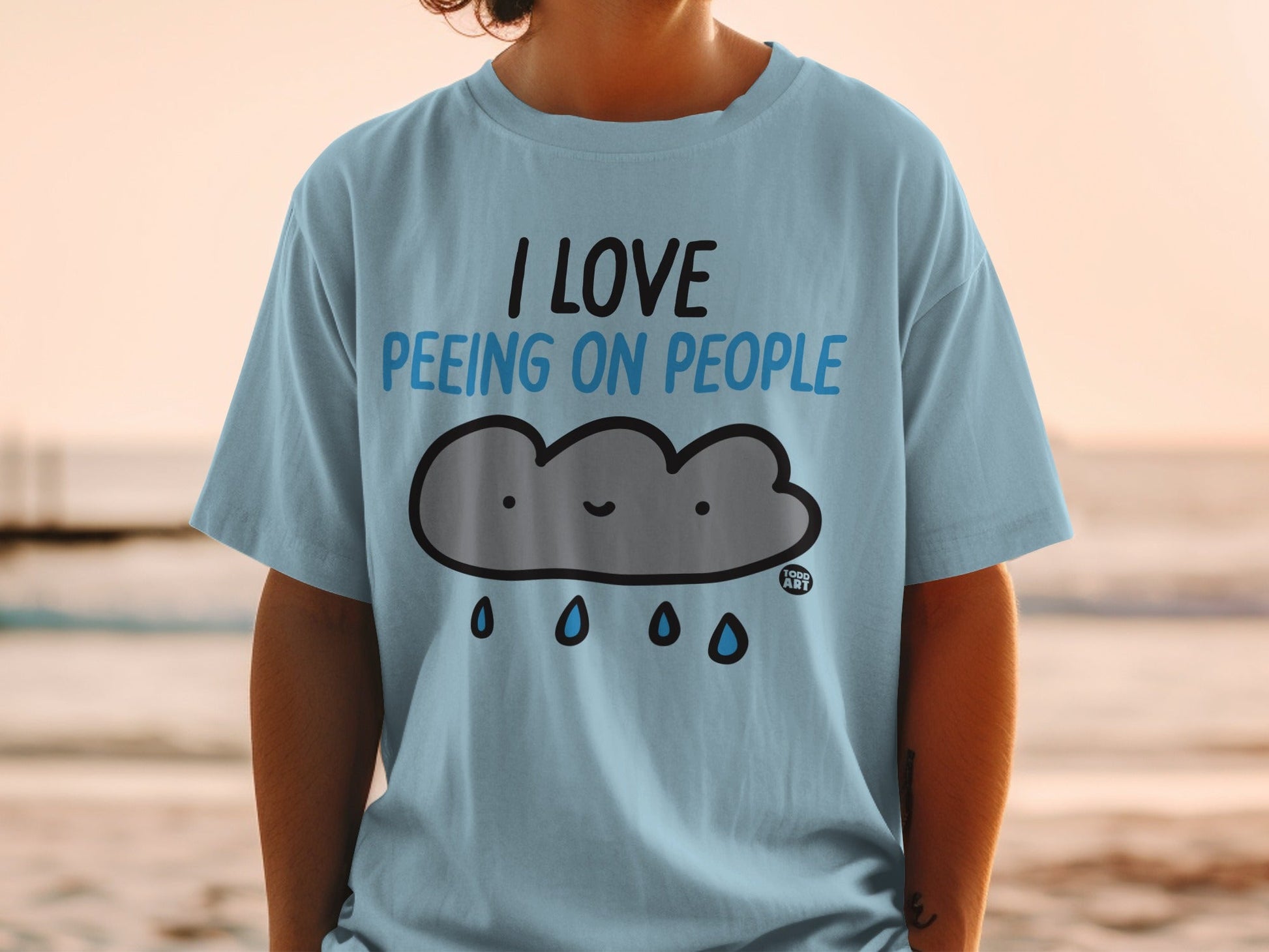 Light blue t-shirt with a smiling cloud and "I LOVE PEEING ON PEOPLE" text.