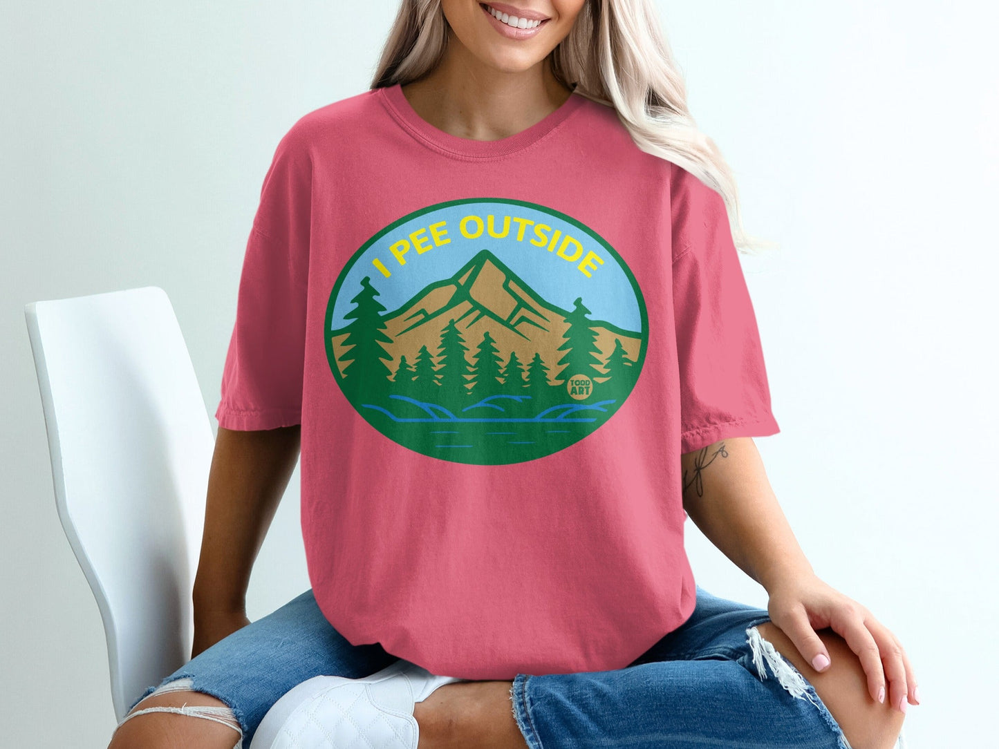 Teal oval with trees, mountains, and lake; text reads "I PEE OUTSIDE".