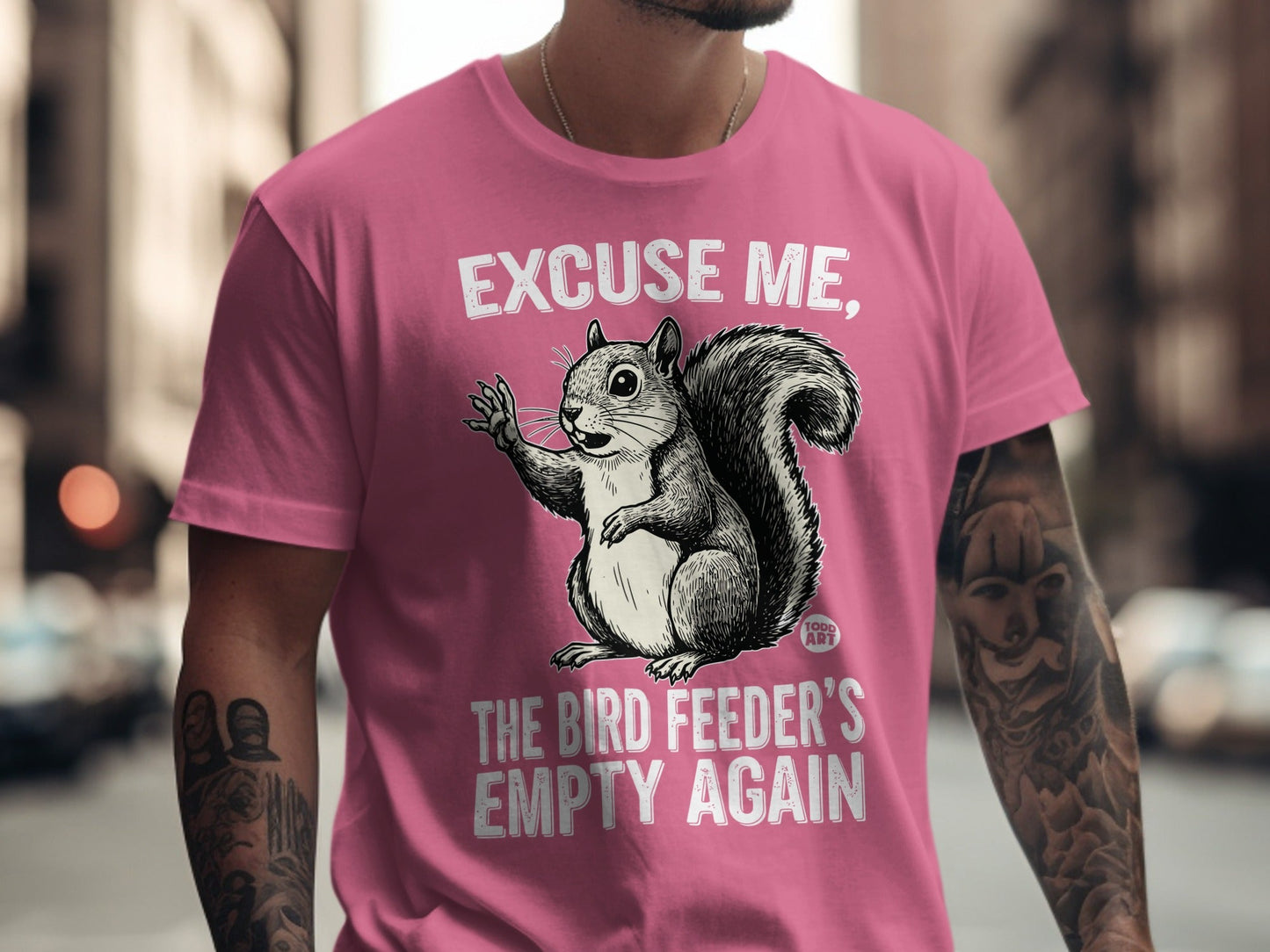 Pink t-shirt with "Excuse me, the bird feeder's empty again" and a squirrel graphic.