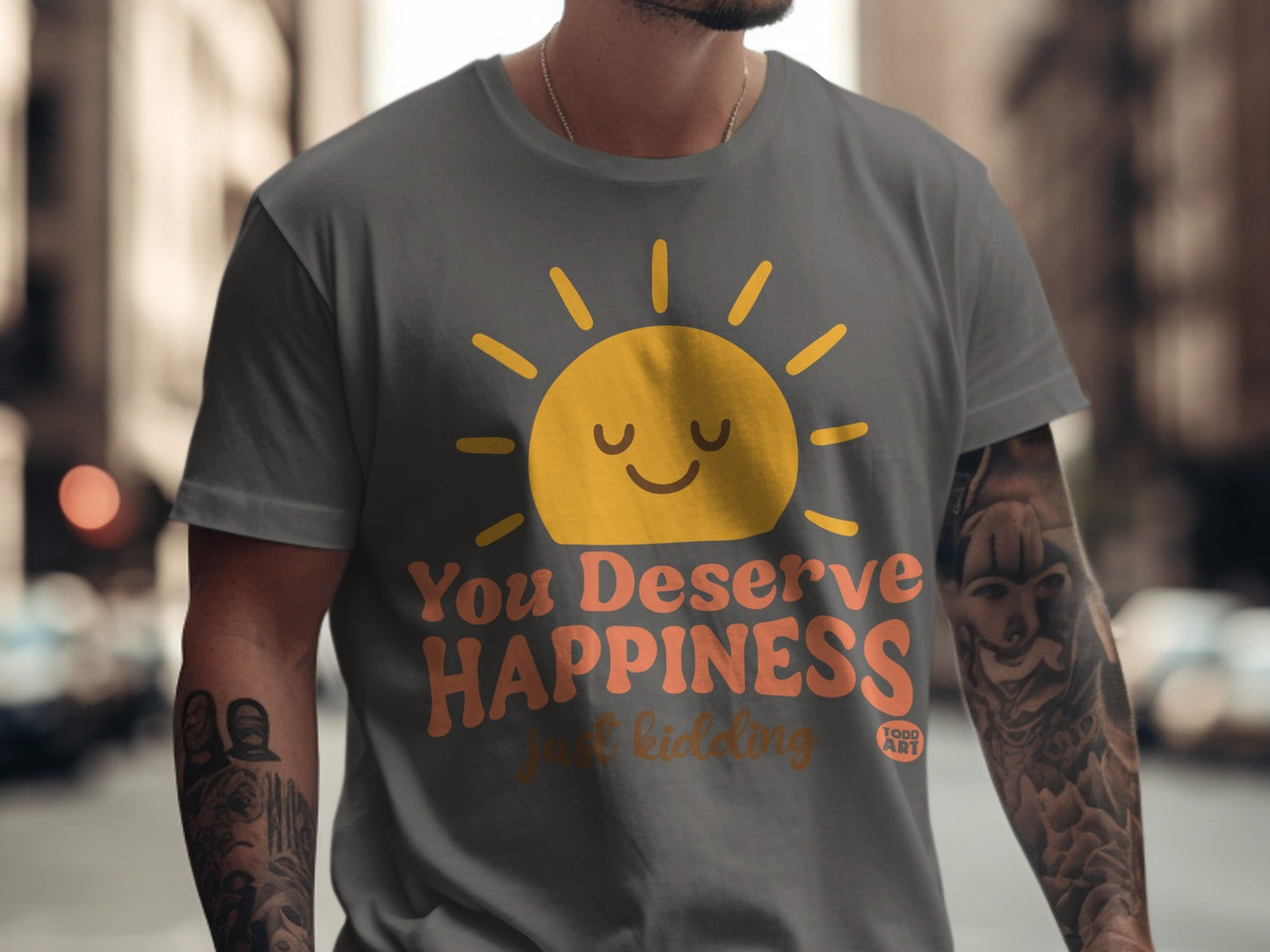 Grey t-shirt with a smiling sun graphic and text "You Deserve Happiness just kidding"