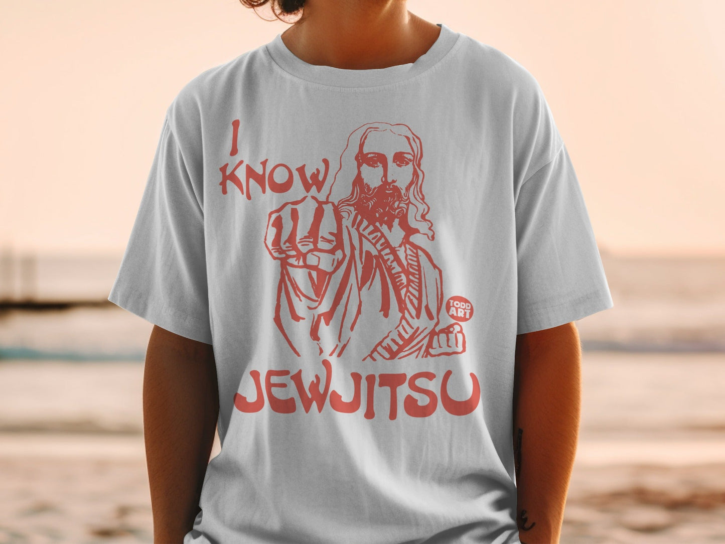 White t-shirt with red graphic of Jesus pointing and text "I KNOW JEWJITSU".