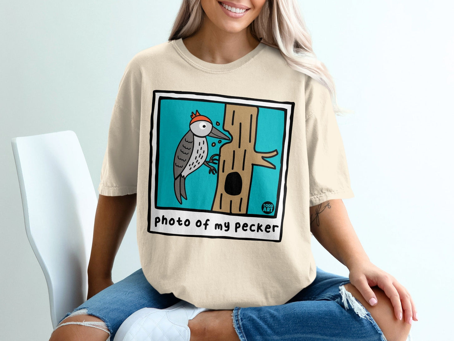 Woodpecker perched on a tree trunk with "photo of my pecker" text.