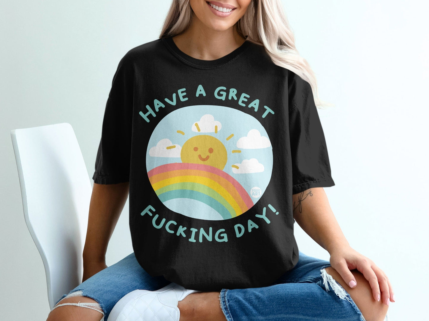 Black t-shirt with a sun, rainbow, and text "Have a great fucking day!".