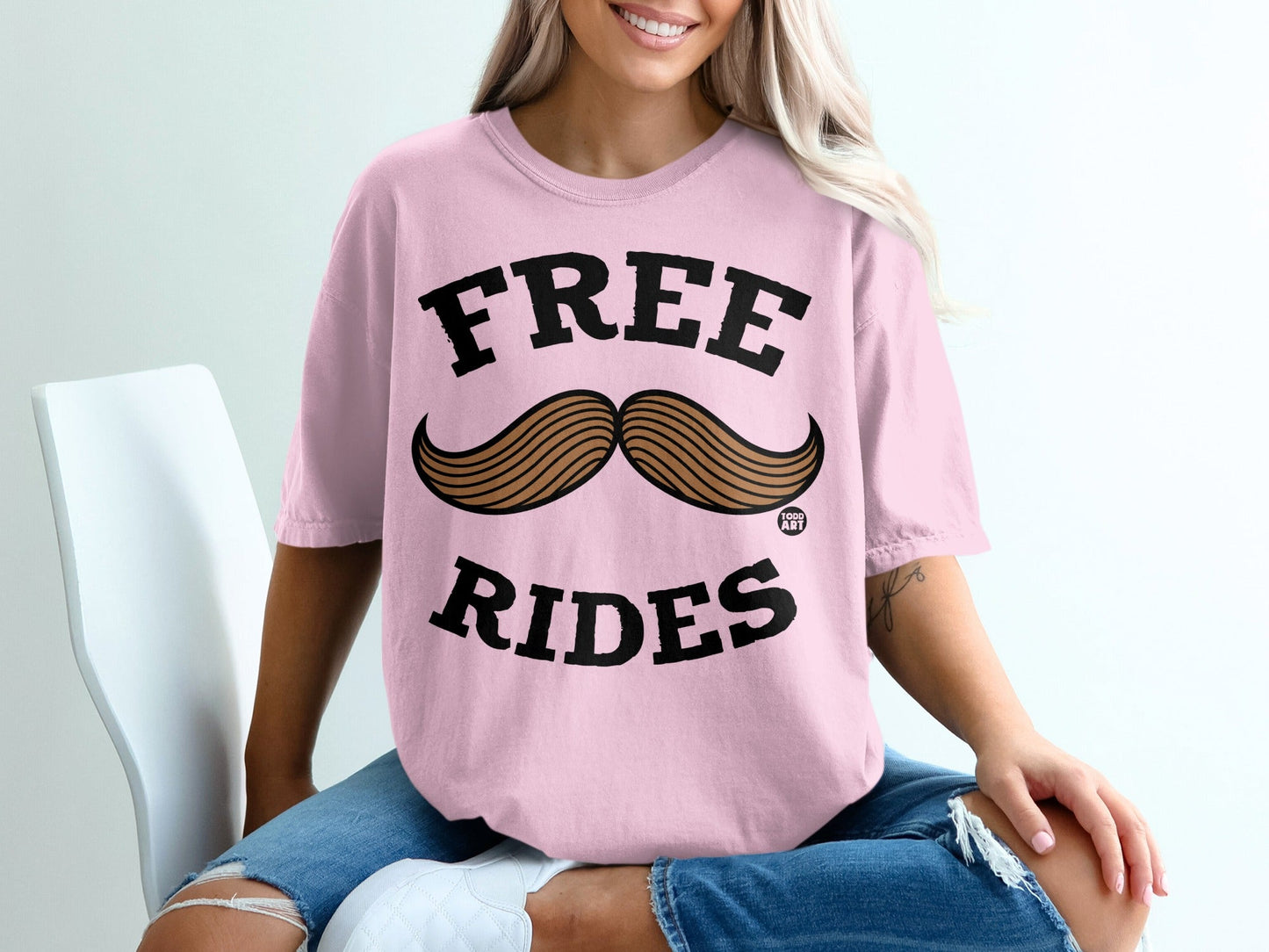 Pink t-shirt with "FREE RIDES" and a mustache graphic.