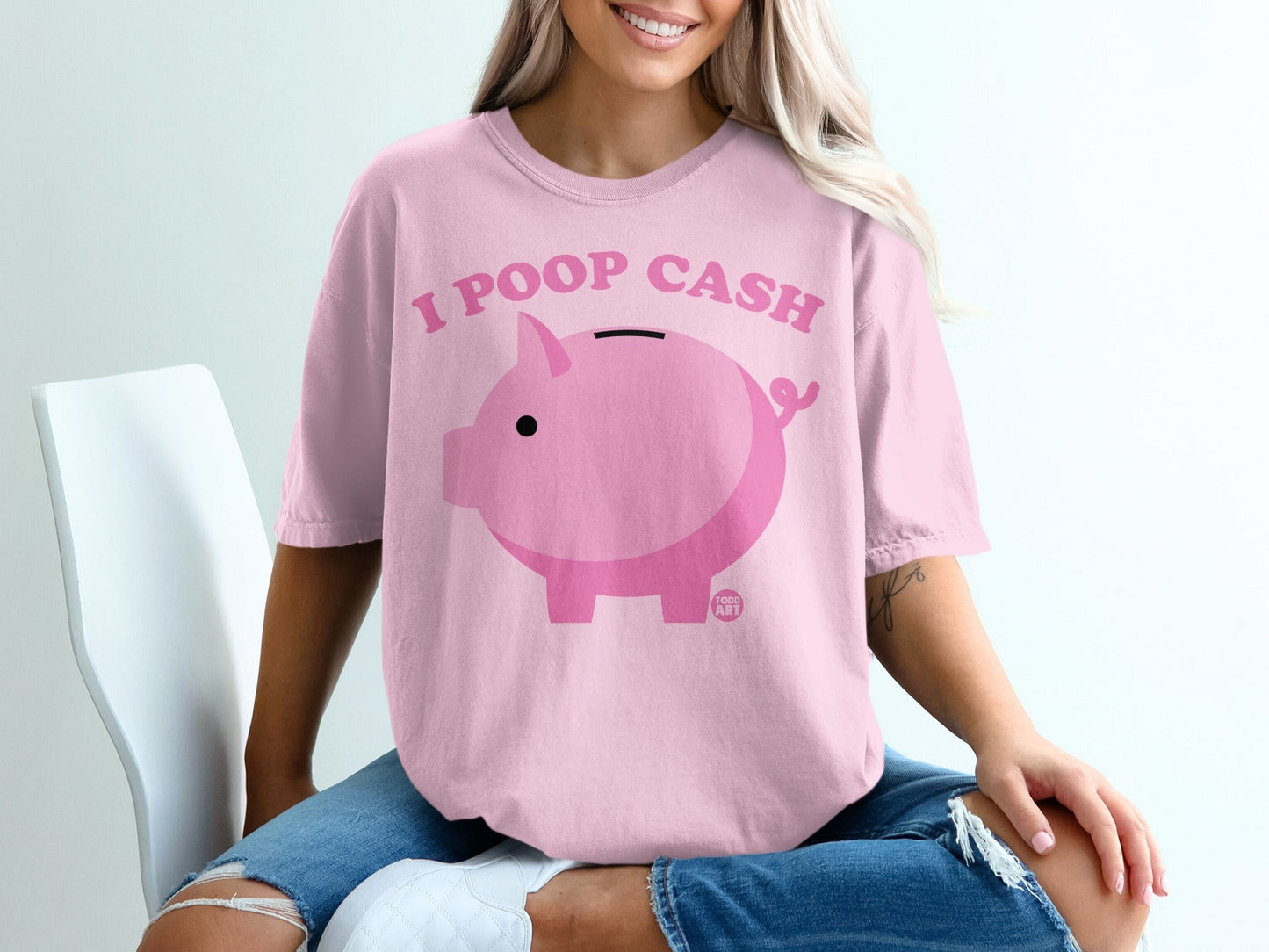 Pink t-shirt with "I POOP CASH" text and a piggy bank.