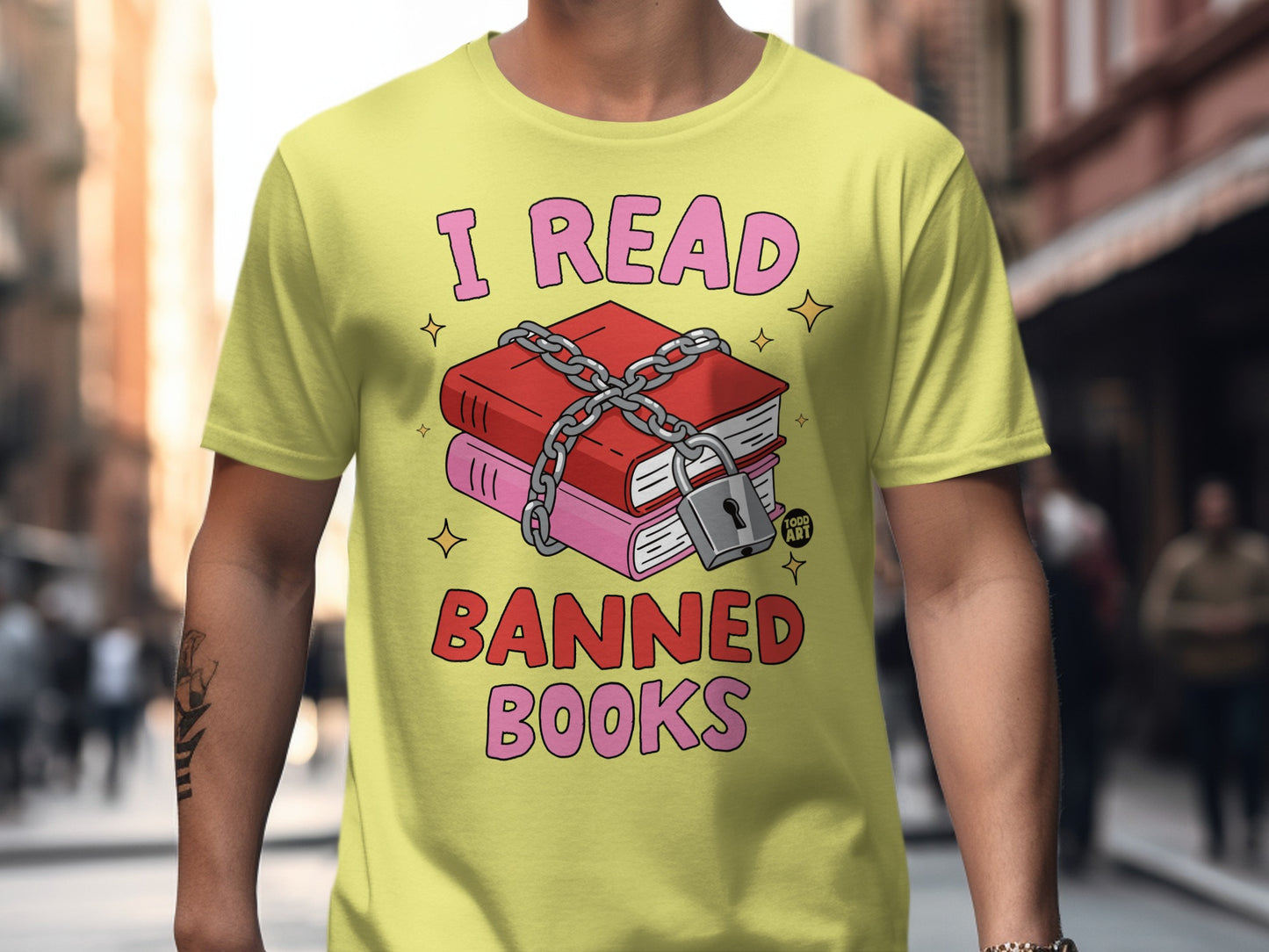 Yellow t-shirt with pink text "I READ" and "BANNED BOOKS" over chained books.