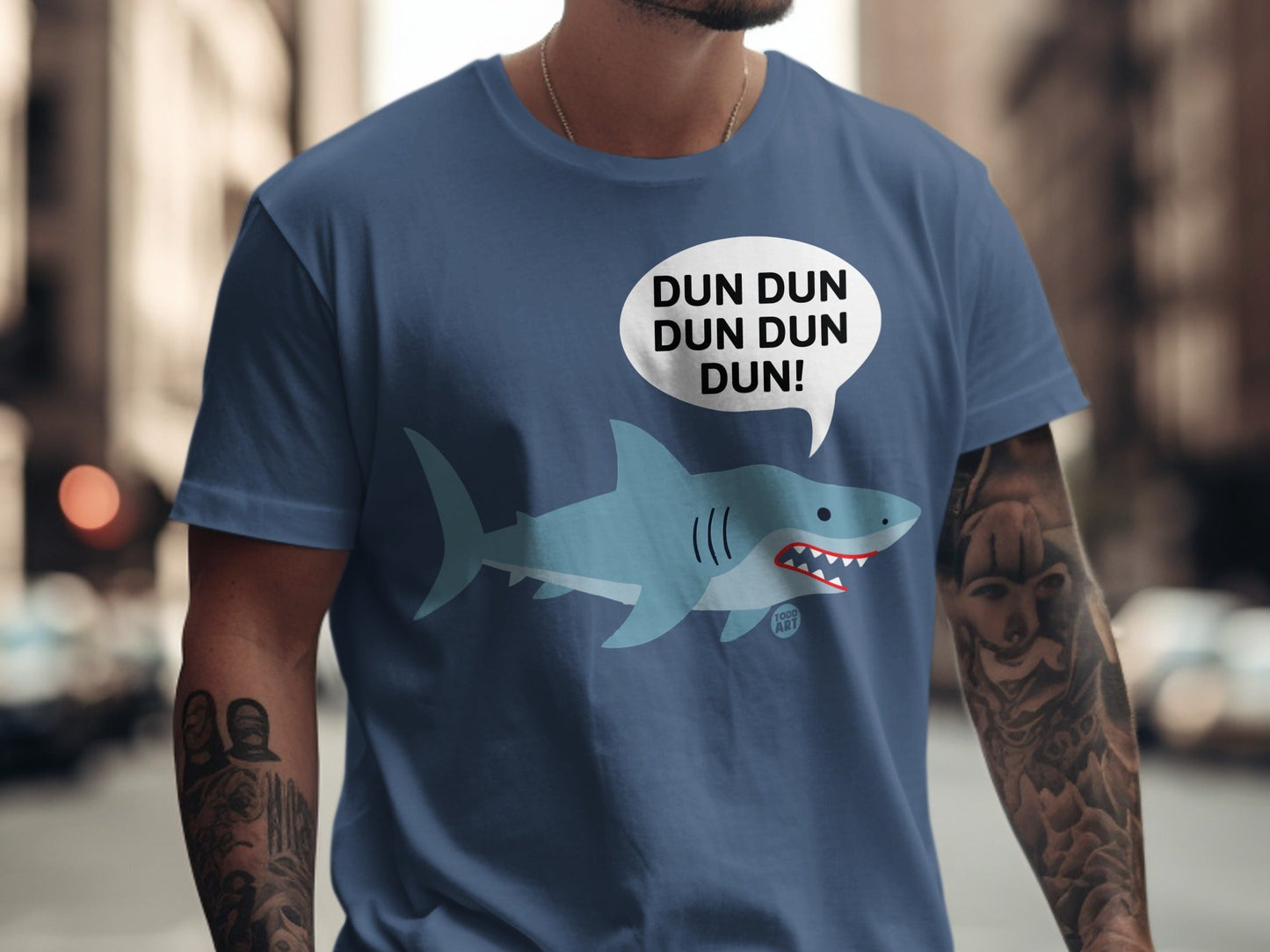 Blue t-shirt with cartoon shark and "DUN DUN DUN DUN!" speech bubble.