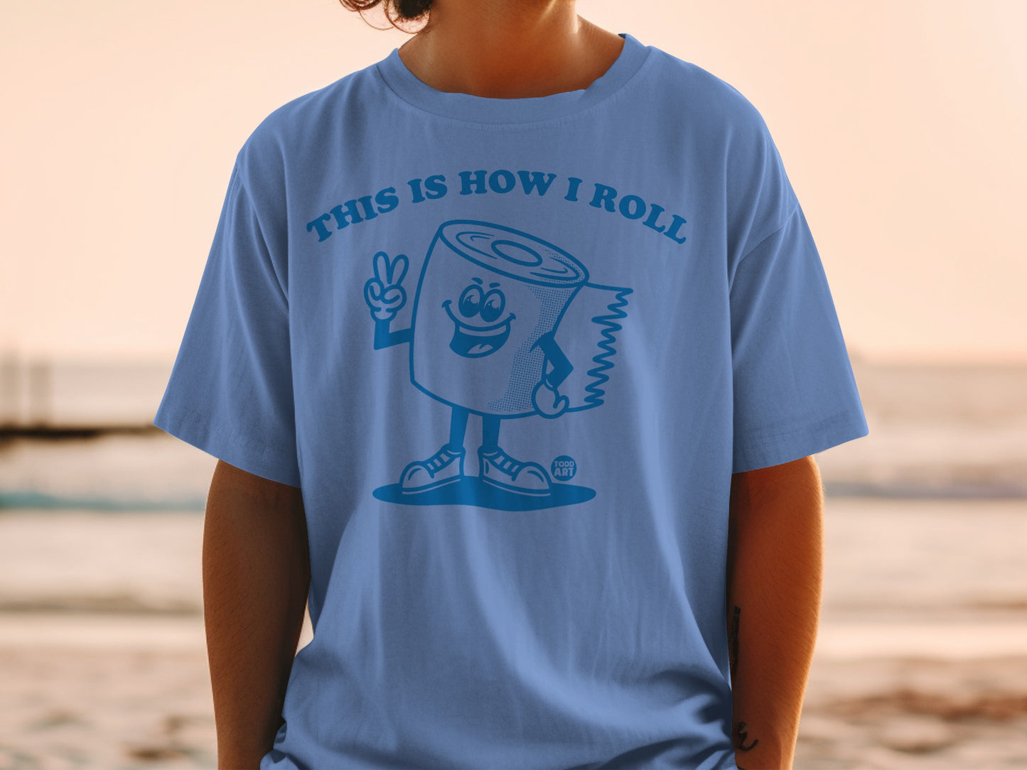 Blue t-shirt with cartoon toilet paper roll giving a peace sign.