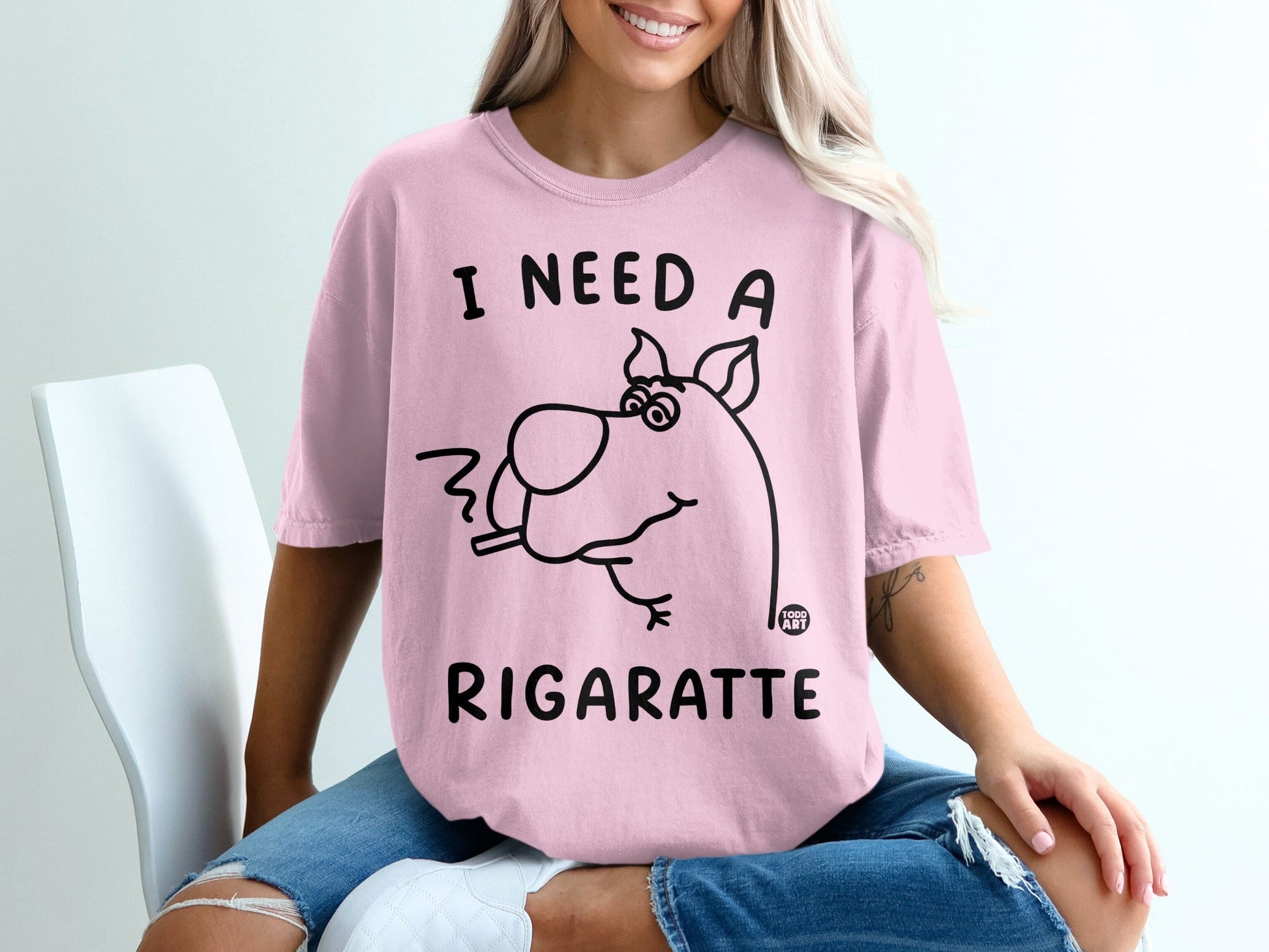 Pink t-shirt with "I need a rigarette" and a cartoon dog smoking.