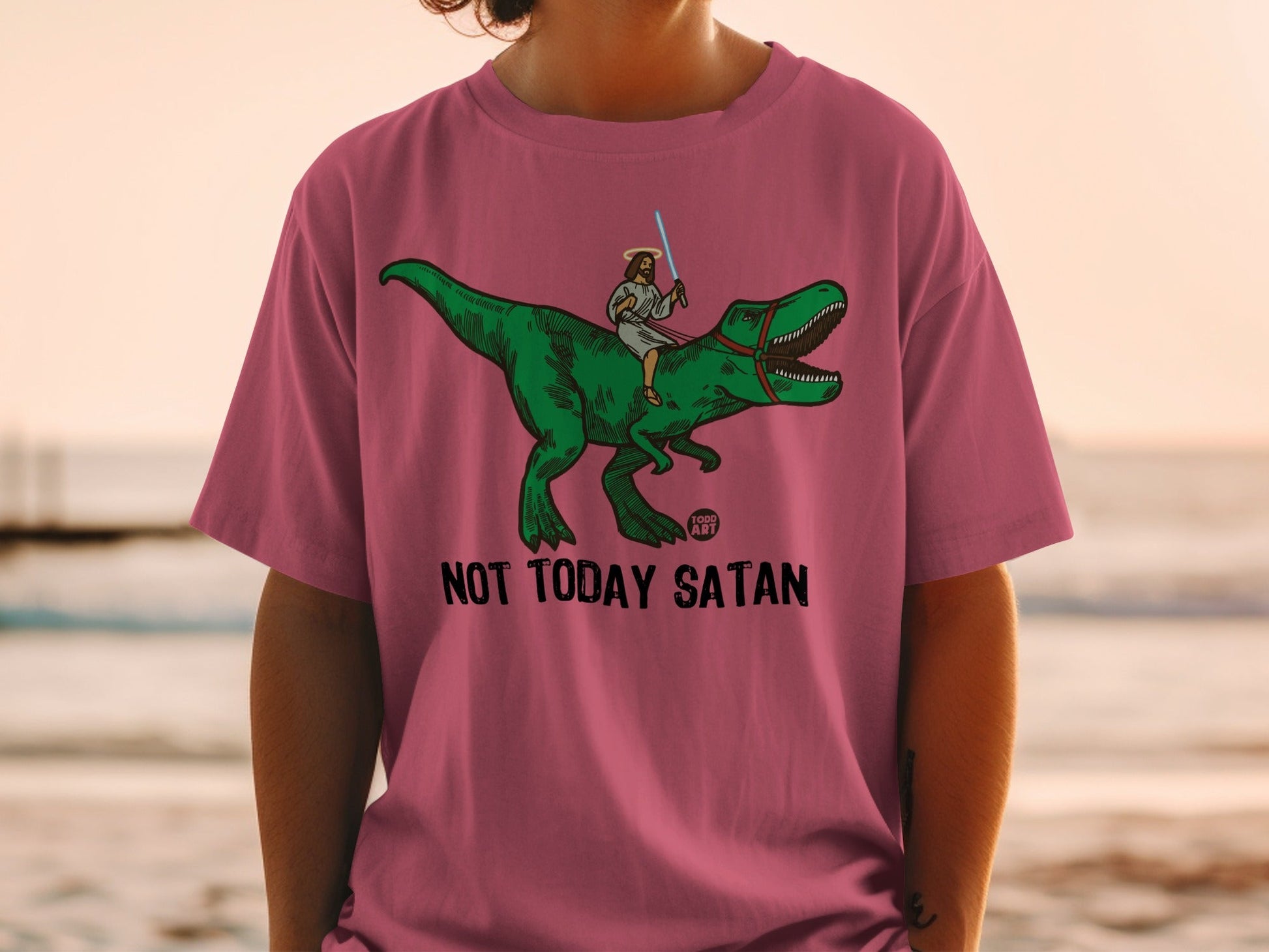 Jesus riding a T-Rex with a lightsaber, text reads "Not Today Satan".