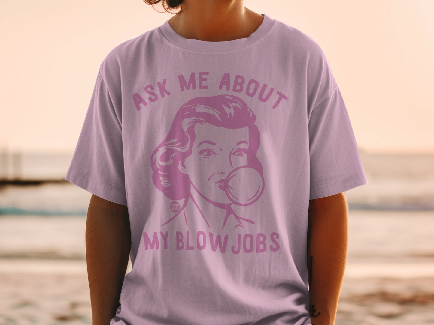 Pink t-shirt with retro woman blowing bubblegum and text "ASK ME ABOUT MY BLOW JOBS".