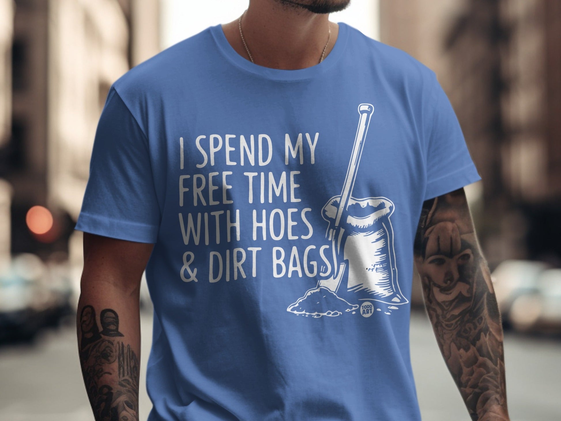 Blue t-shirt with white text and illustration of gardening tools.