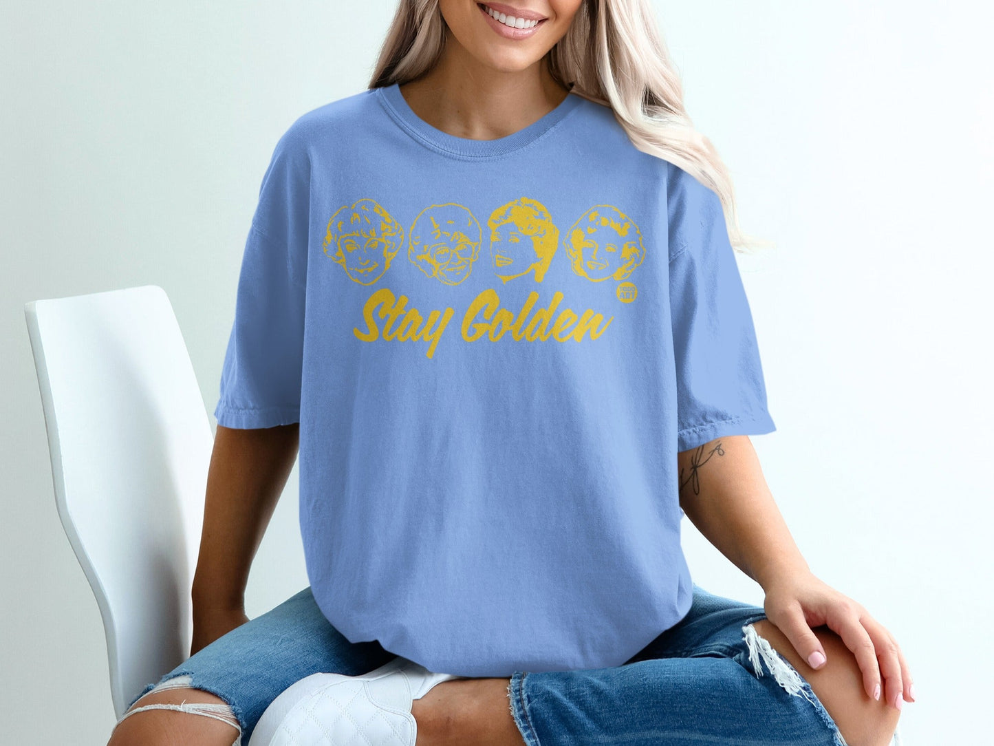 Blue t-shirt with "Stay Golden" text and cartoon portraits.