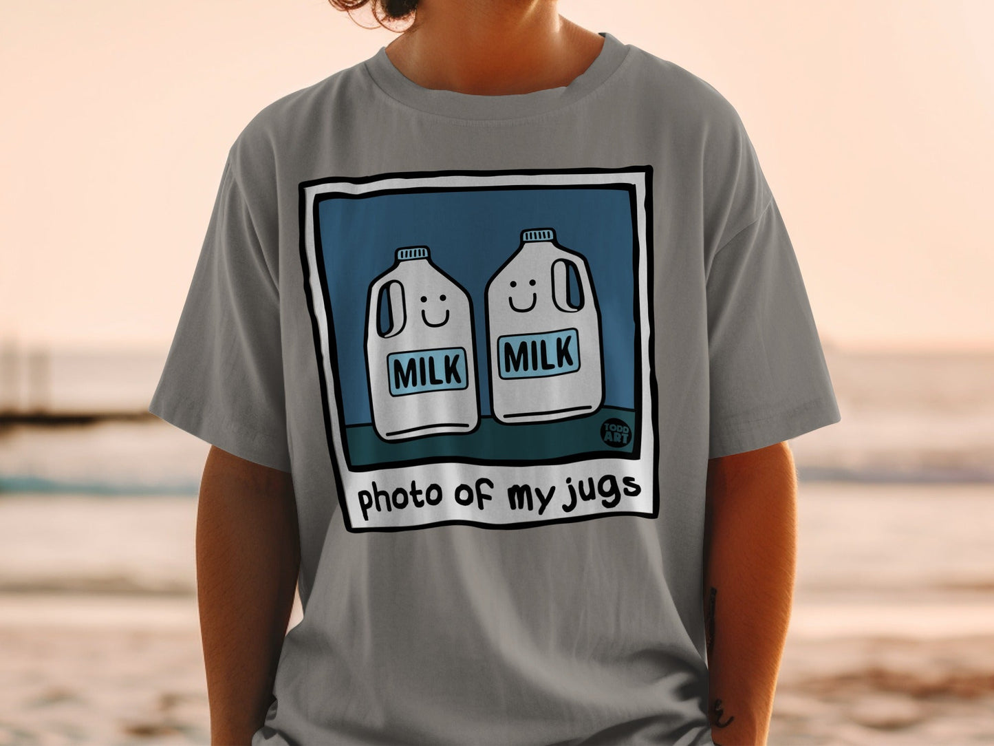 T-shirt with illustration of two smiling milk jugs, text "photo of my jugs".
