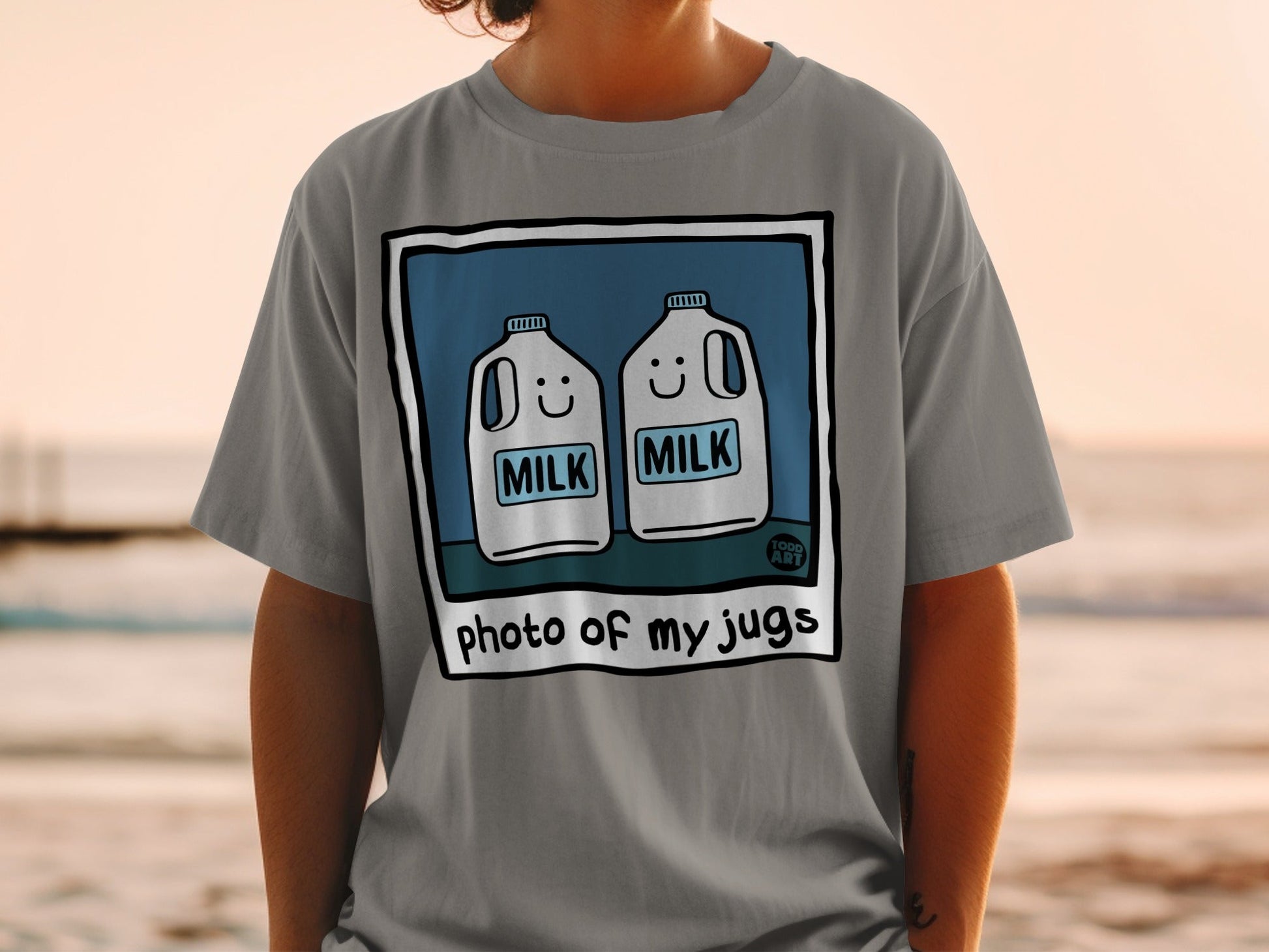 T-shirt with illustration of two smiling milk jugs, text "photo of my jugs".