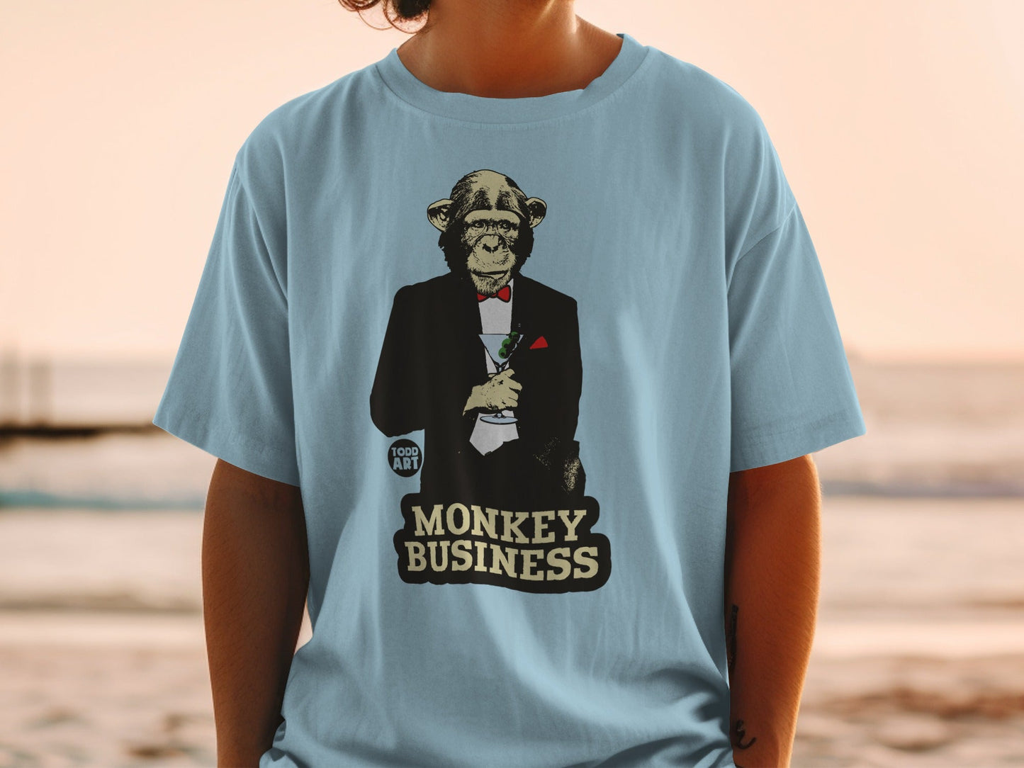 T-shirt with a monkey in a tuxedo holding a cocktail, text reads "MONKEY BUSINESS".
