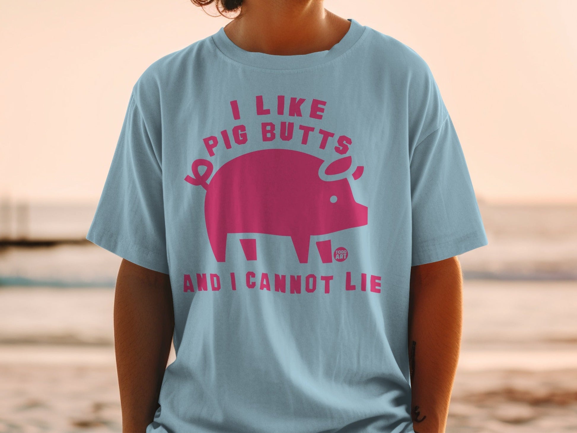 Light blue t-shirt with pink pig graphic and text "I LIKE PIG BUTTS AND I CANNOT LIE".
