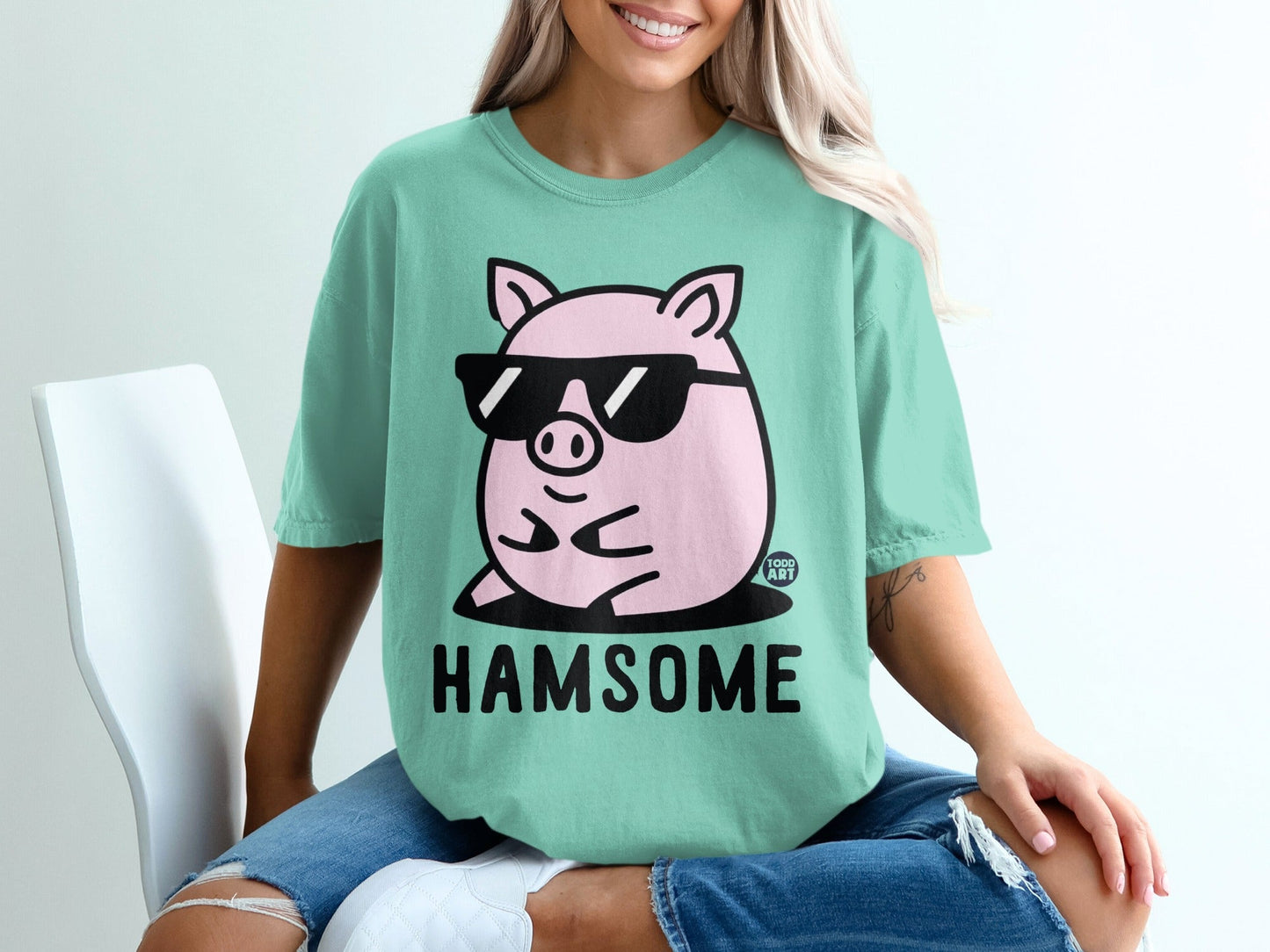 Mint t-shirt with a cartoon pig wearing sunglasses and text that reads "HAMSOME".