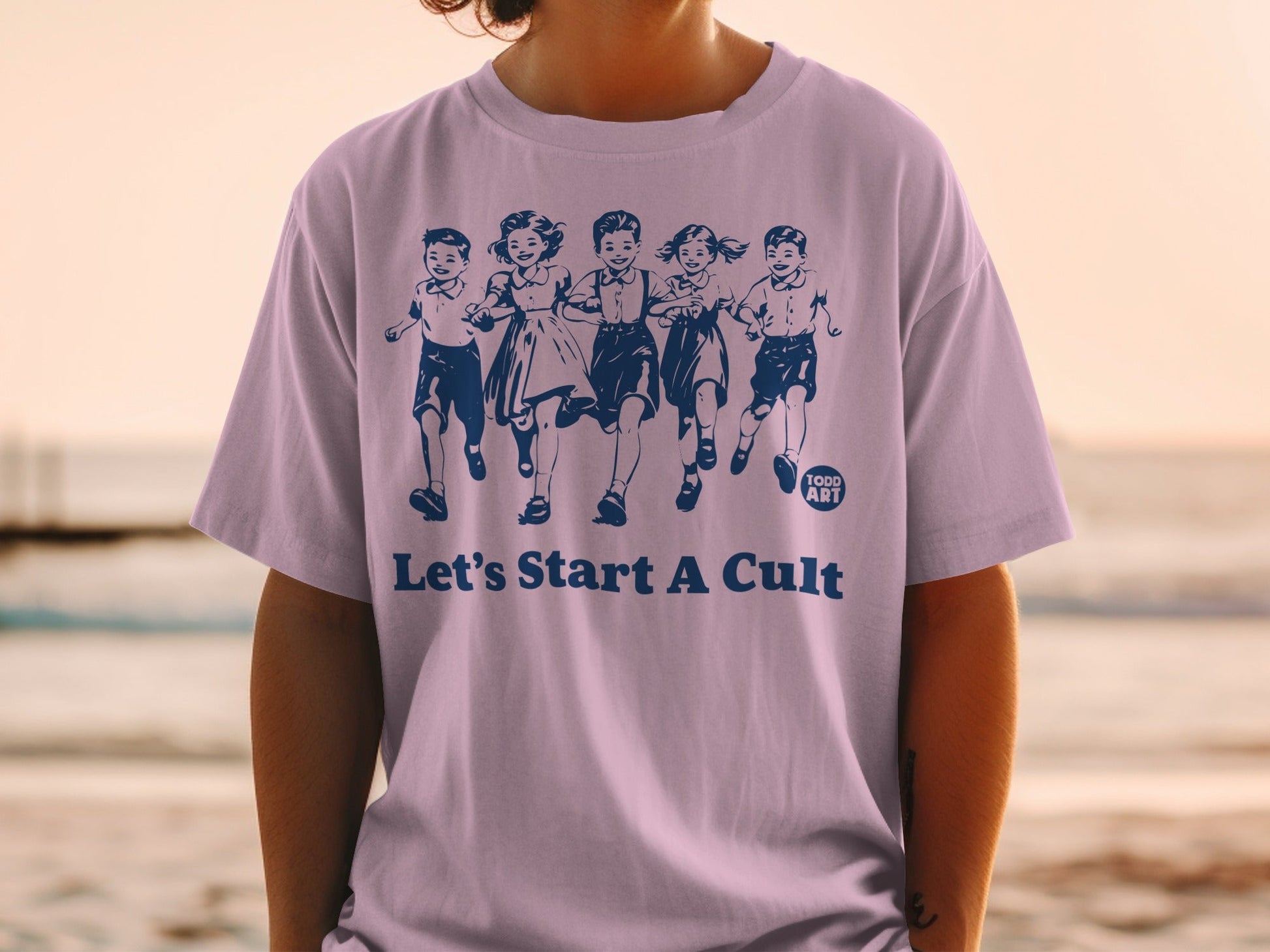 Purple t-shirt with navy print of children running and "Let's Start A Cult".