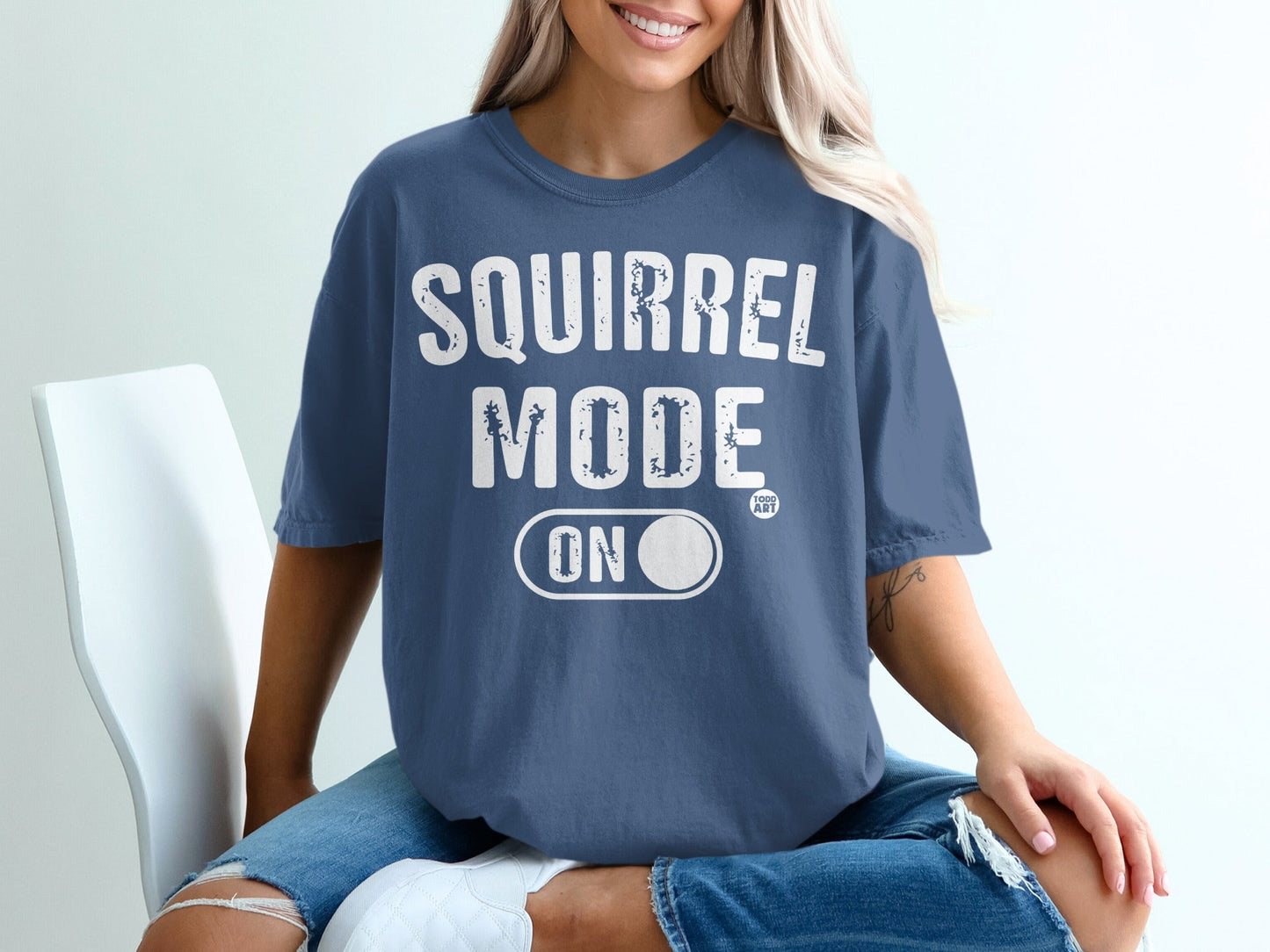 Blue t-shirt with "Squirrel Mode ON" text and a small circle logo.