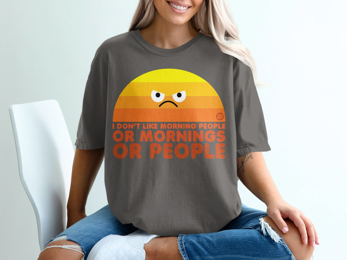 Dark grey t-shirt with a grumpy sun graphic and "I DON'T LIKE MORNING PEOPLE OR PEOPLE" text.