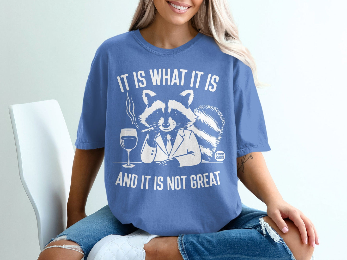 Raccoon in suit smoking and drinking wine, text "IT IS WHAT IT IS AND IT IS NOT GREAT".