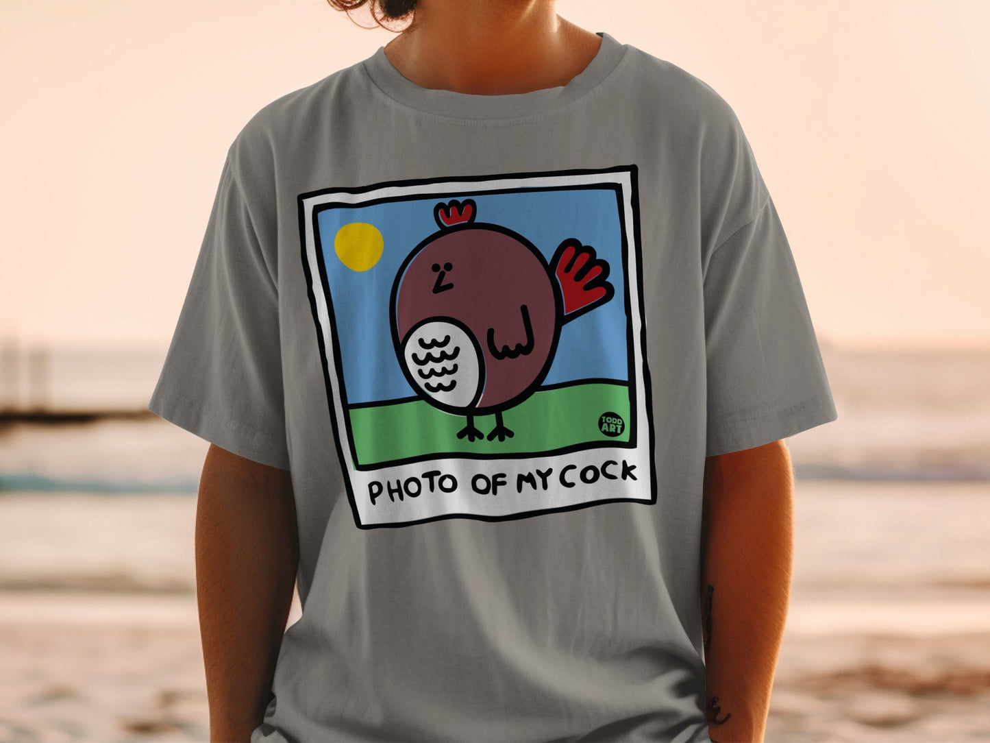 Gray t-shirt featuring a cartoon drawing of a rooster with "PHOTO OF MY COCK" text.