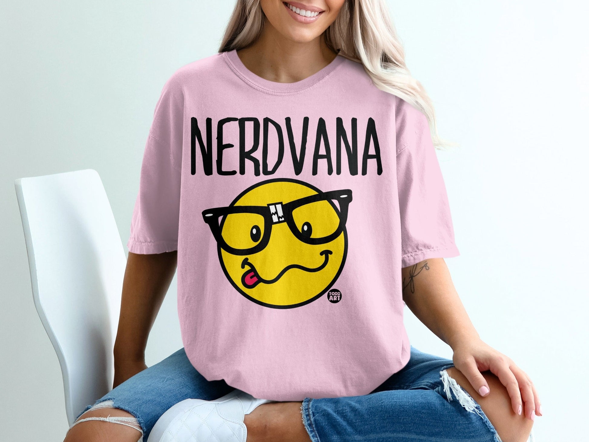 Pink t-shirt with "NERDVANA" text and a smiley face wearing glasses.
