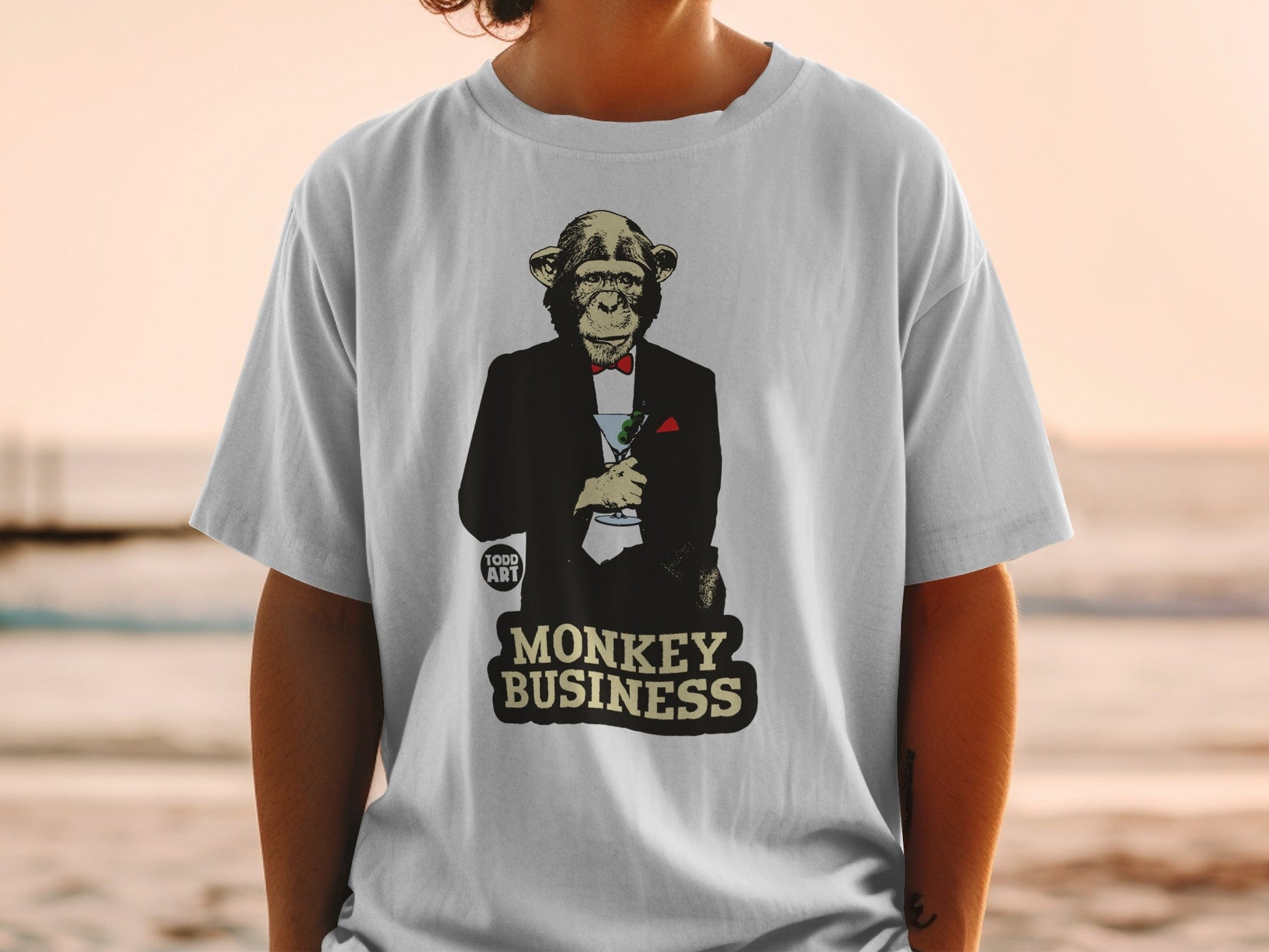 T-shirt with a monkey in a tuxedo holding a martini glass, text "MONKEY BUSINESS".