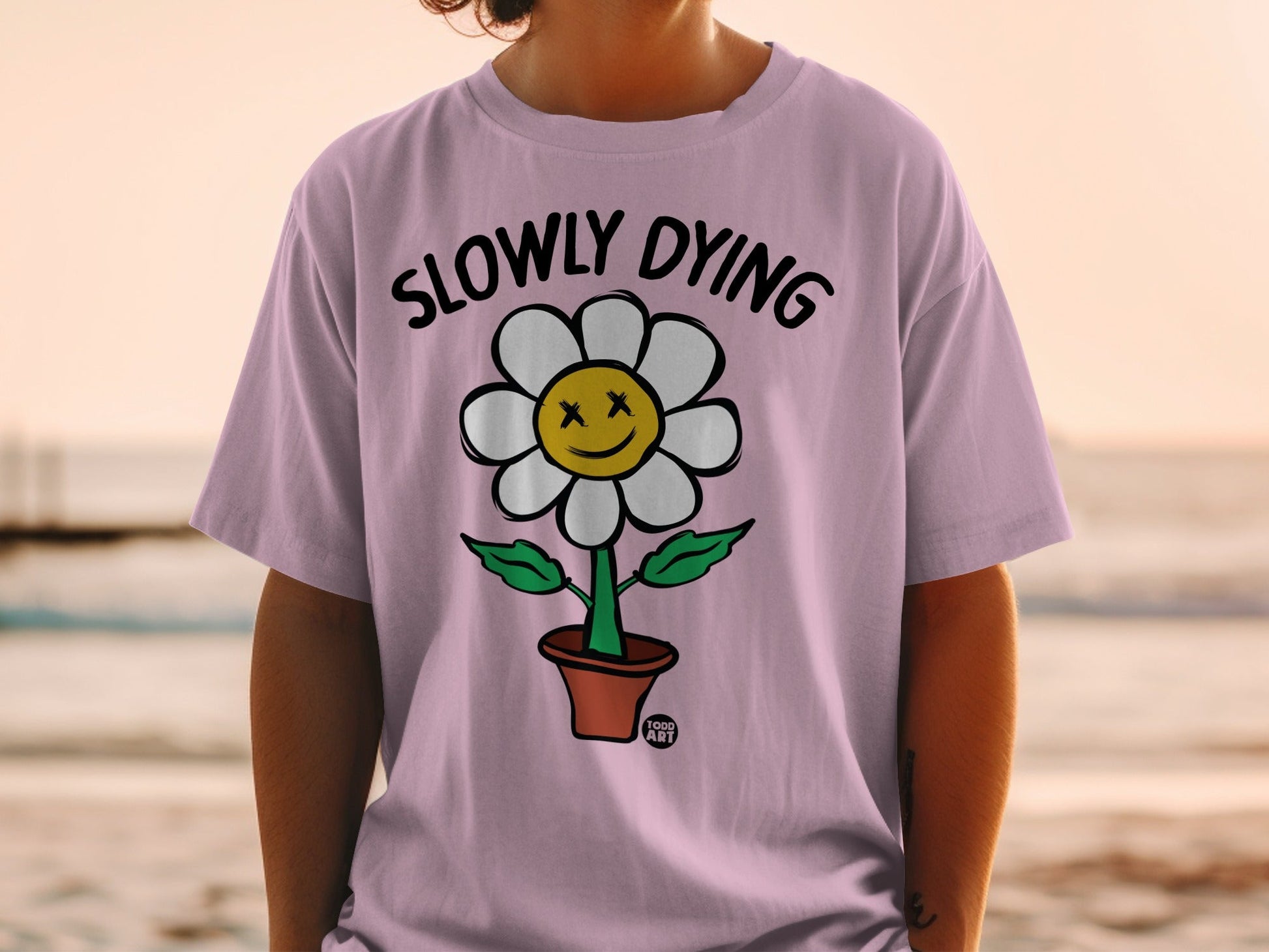 Pink t-shirt with a flower wearing sunglasses and a smiley face.