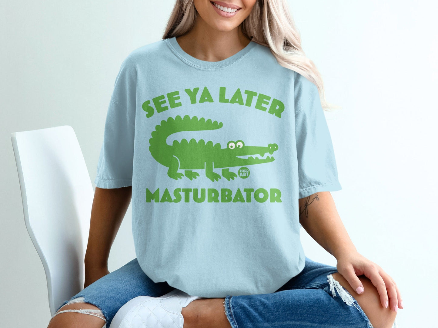 Light blue t-shirt with green alligator graphic and text "SEE YA LATER MASTURBATOR".