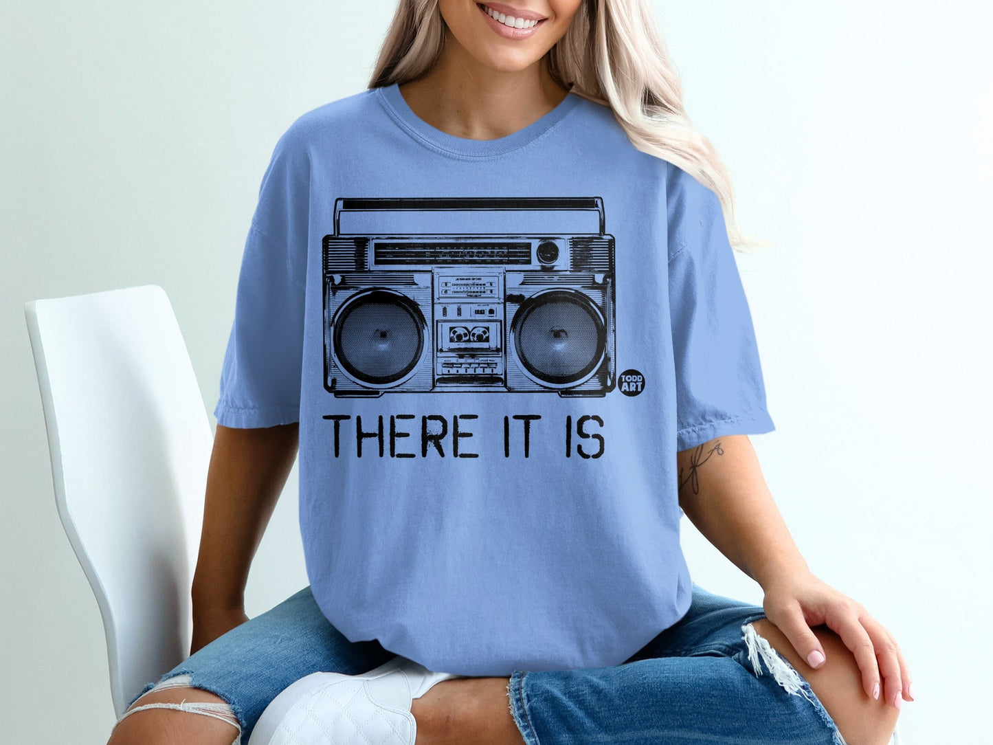 Blue t-shirt with black graphic of a boombox and text "THERE IT IS".
